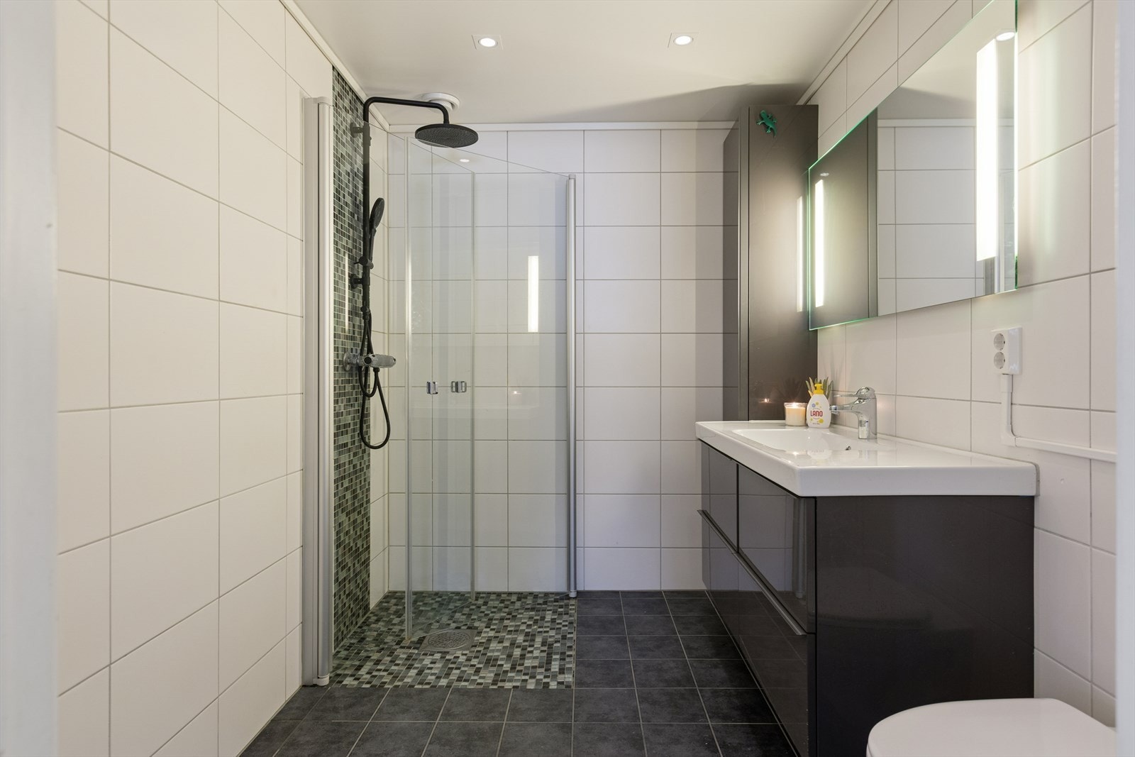 Stilrent flislagt bad med downlights i himling. Galleribilde