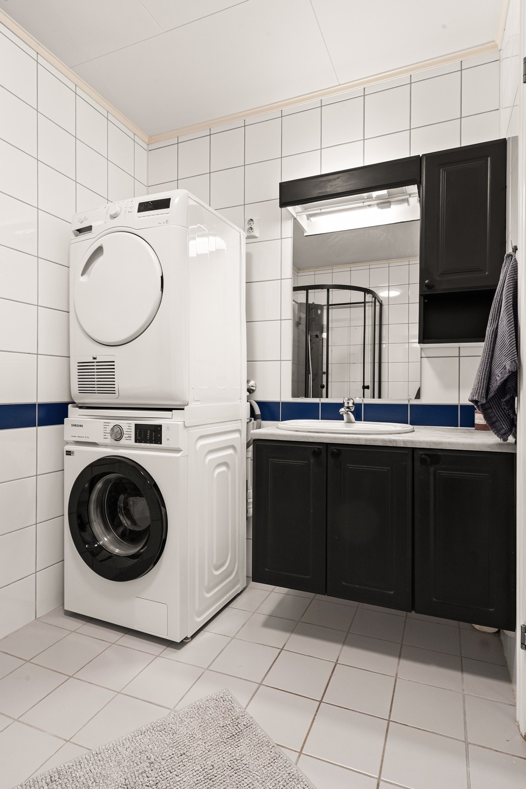 Innredning med svarte profilerte fronter og opplegg for vaskemaskin Galleribilde