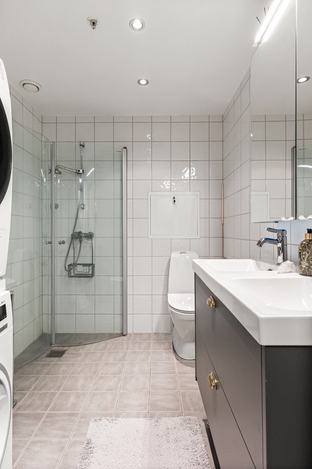 Funksjonelt bad med flislagte overflater på både gulv og vegger. Den slette himlingen med innfelte spotter sørger for god og jevn belysning. Galleribilde