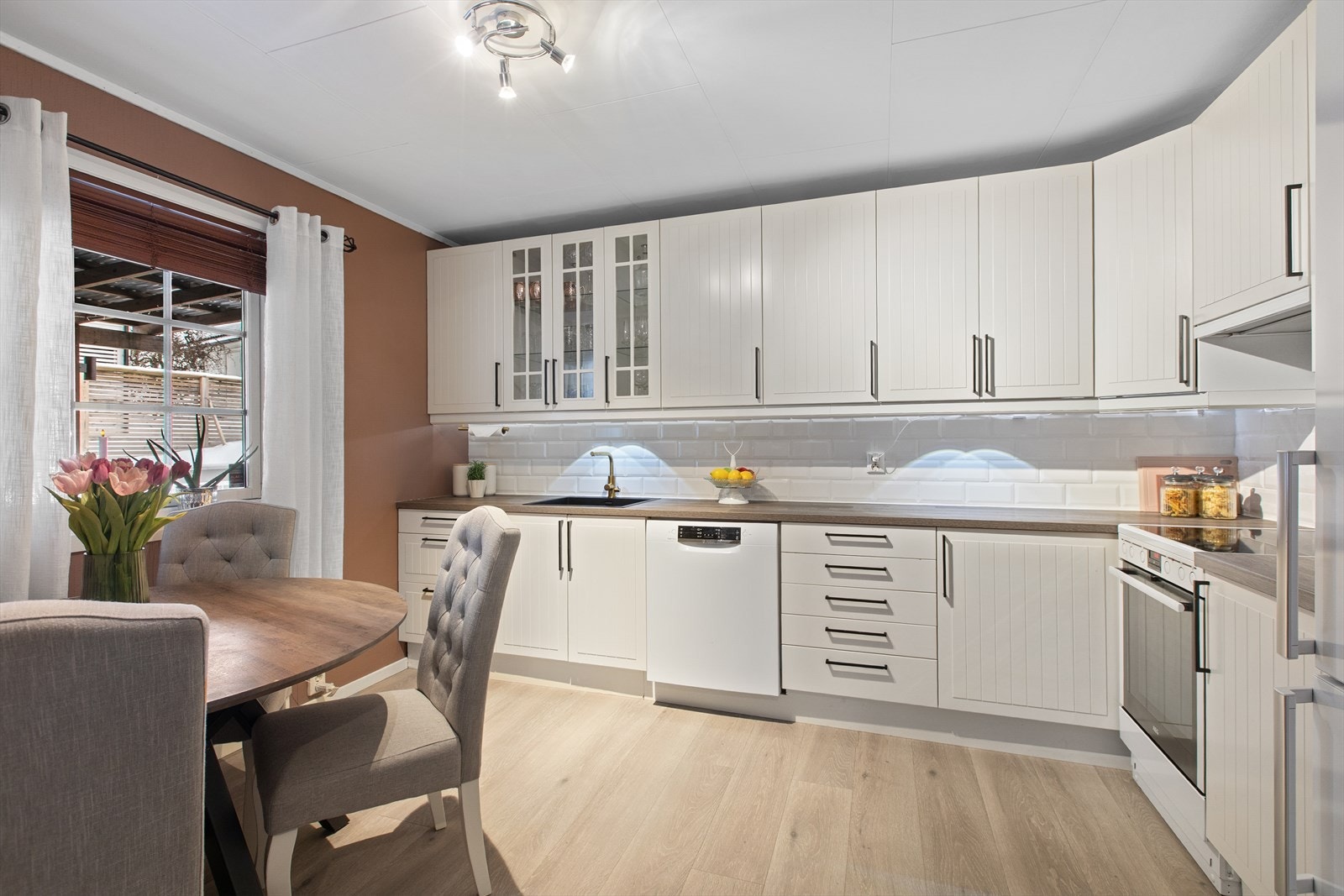 Kjøkkenet er et eget rom med en pen innredning med hvite, profilerte fronter. Galleribilde