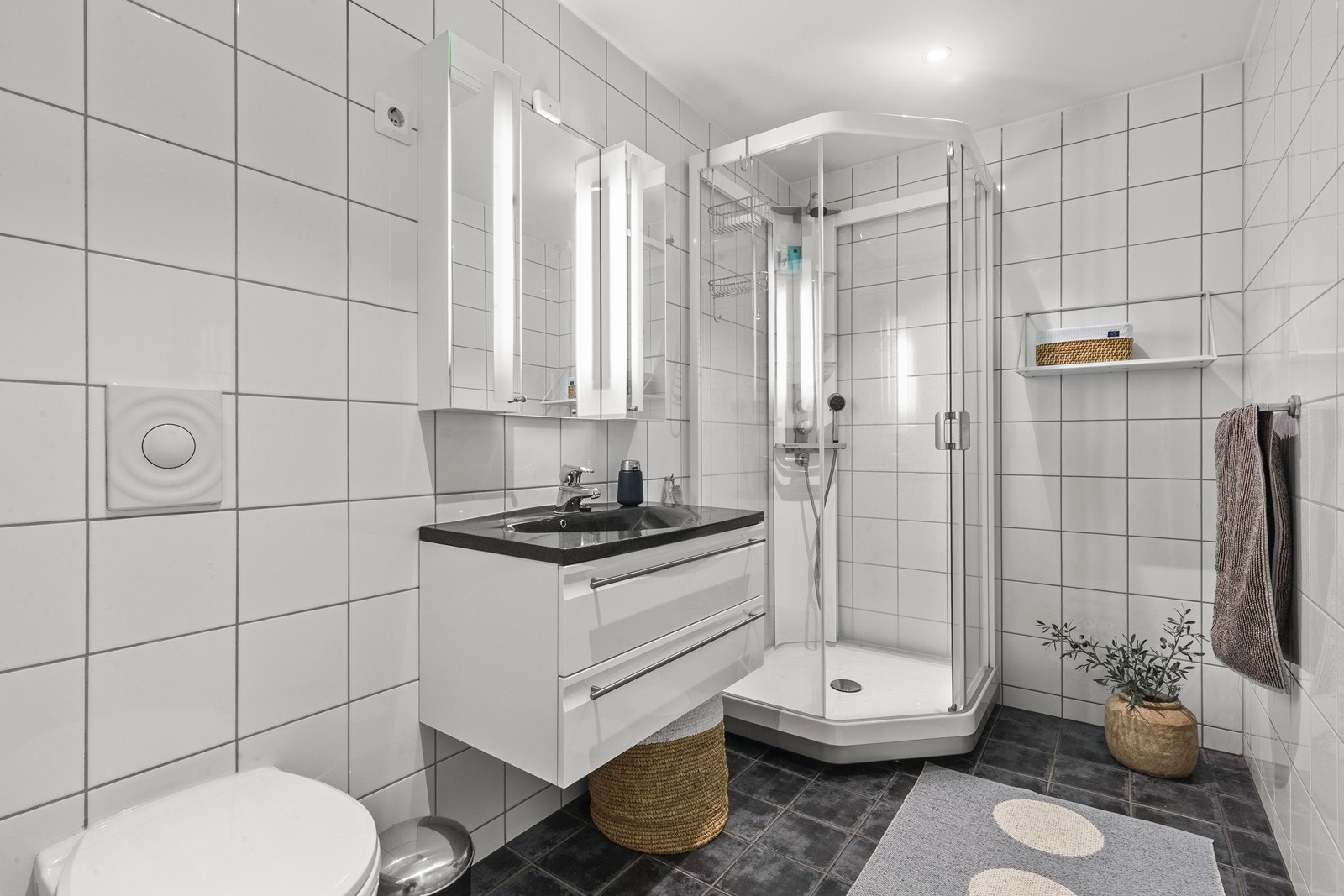 Delikat og tidløst bad med dusjkabinett, vegghengt toalett og servant med lagringsplass Galleribilde