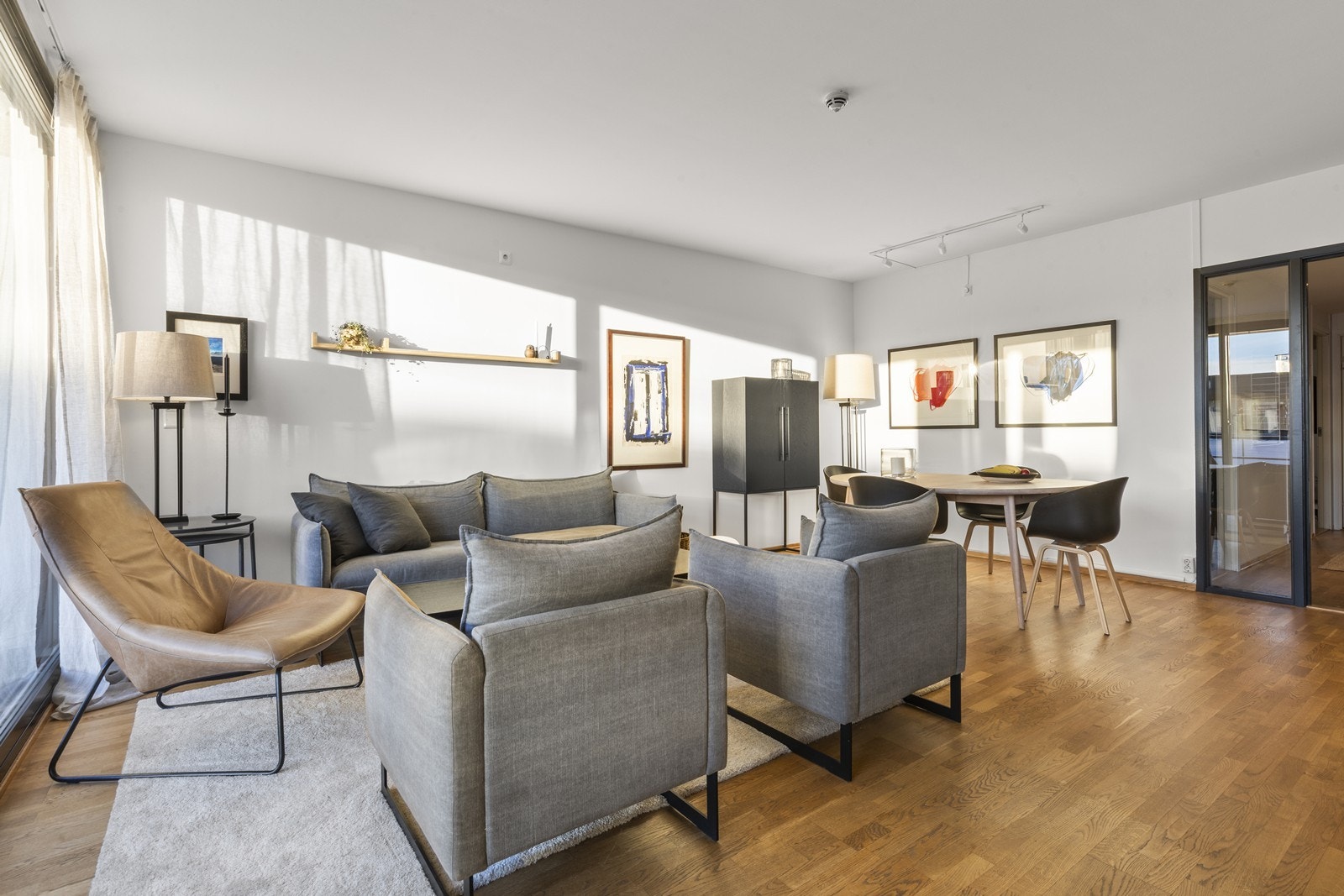 Stuen har enkelt møbleres med sofagruppe og spisebord Galleribilde