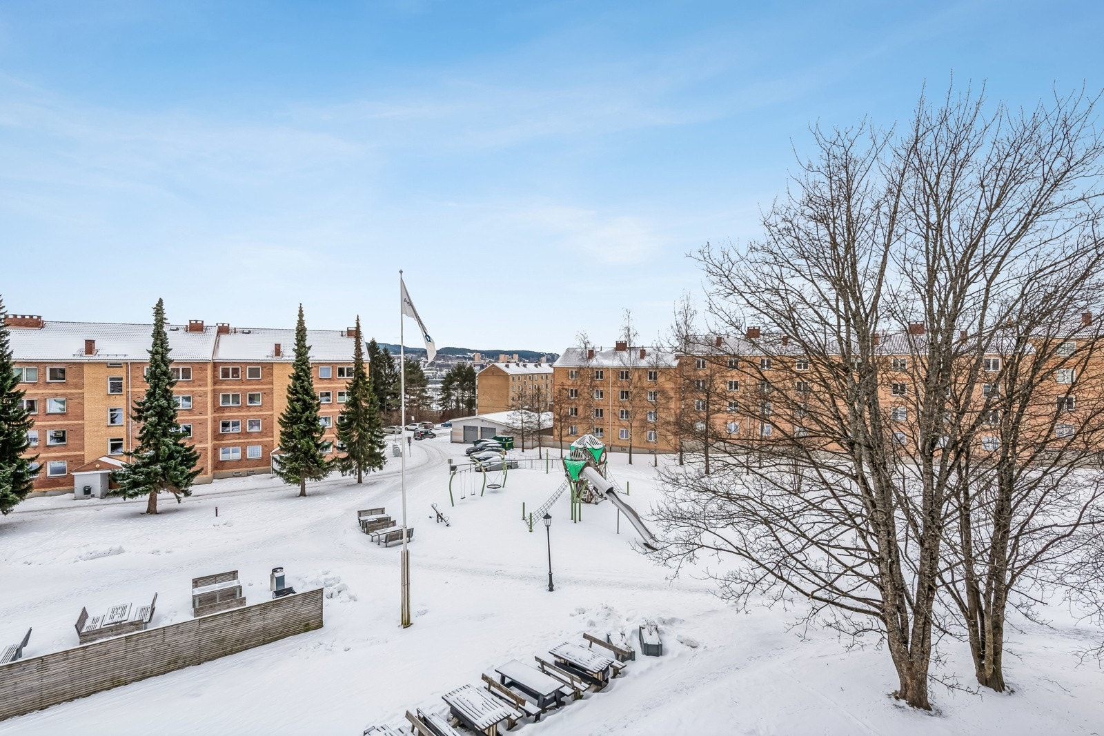 Utsikt fra balkongen til flotte fellesområder som er velstelte hele året. Lekeplassen er godt brukt på sommeren og på vinteren brukes området til aking og lek. Galleribilde