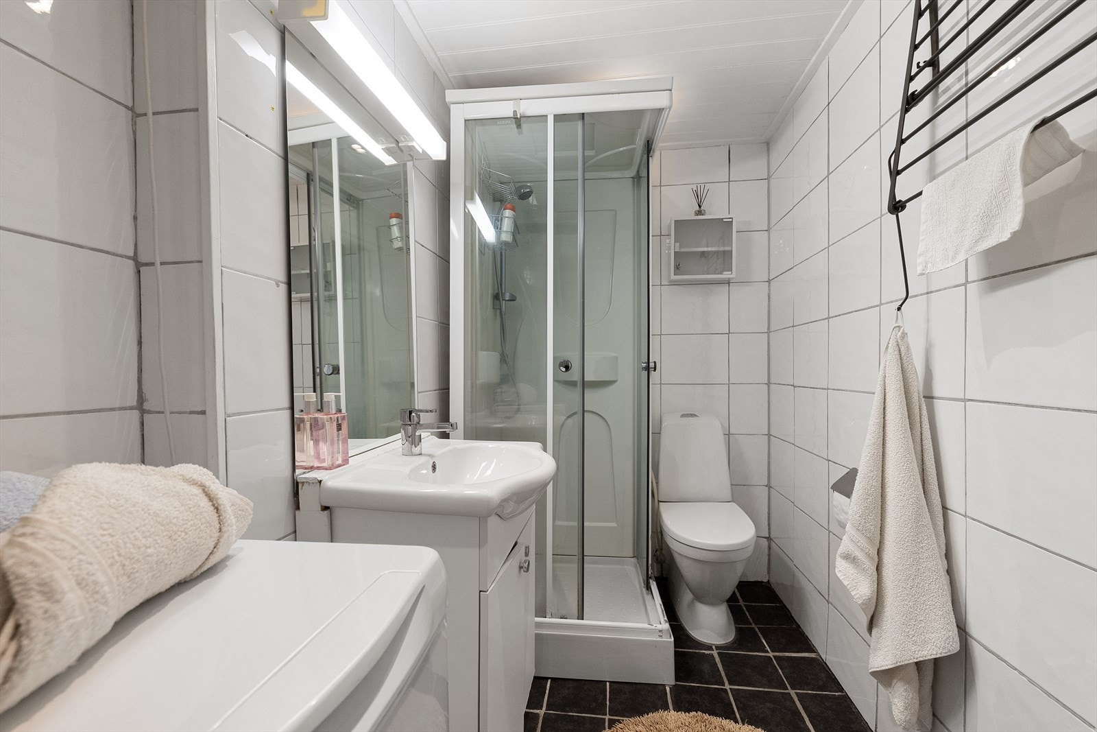 Stort og praktisk bad som er flislagt i lyse farger. Galleribilde