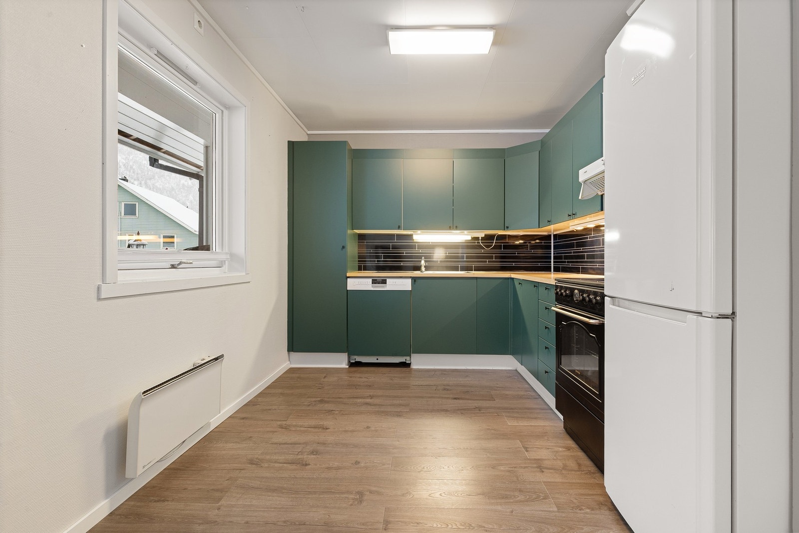 Kjøkkeninnredningen har folierte fronter og kitchenboard er montert under overskap. Galleribilde