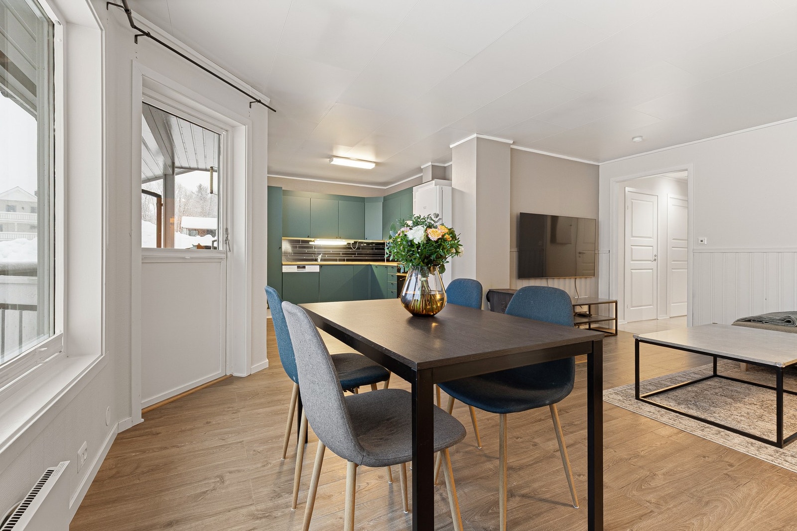 Utgang fra stua til en praktisk terrasse og en tilhørende hage. Galleribilde