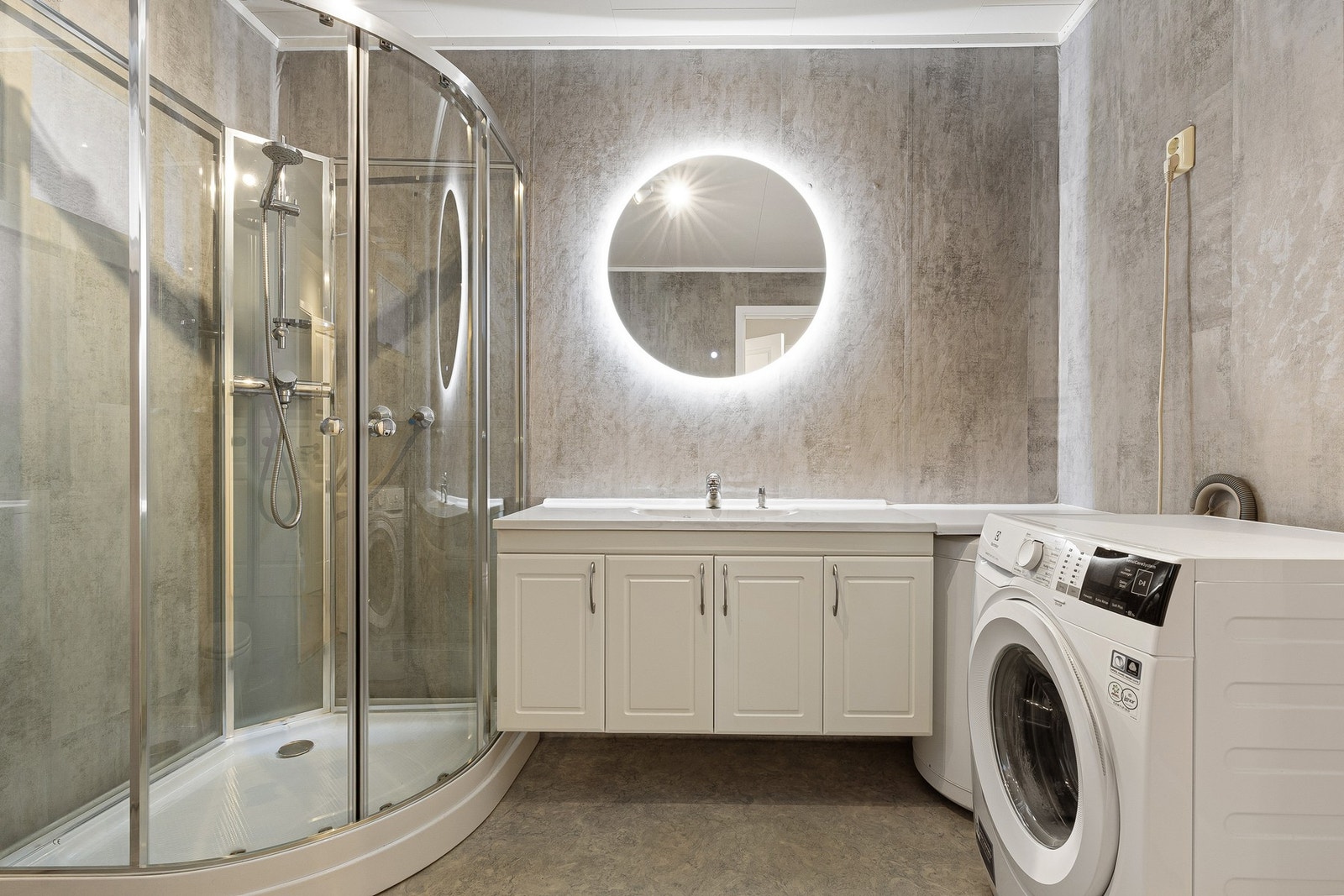 Badet har gulv av vinylbelegg med elektriske varmekabler og veggene har våtromsbelegg. Galleribilde