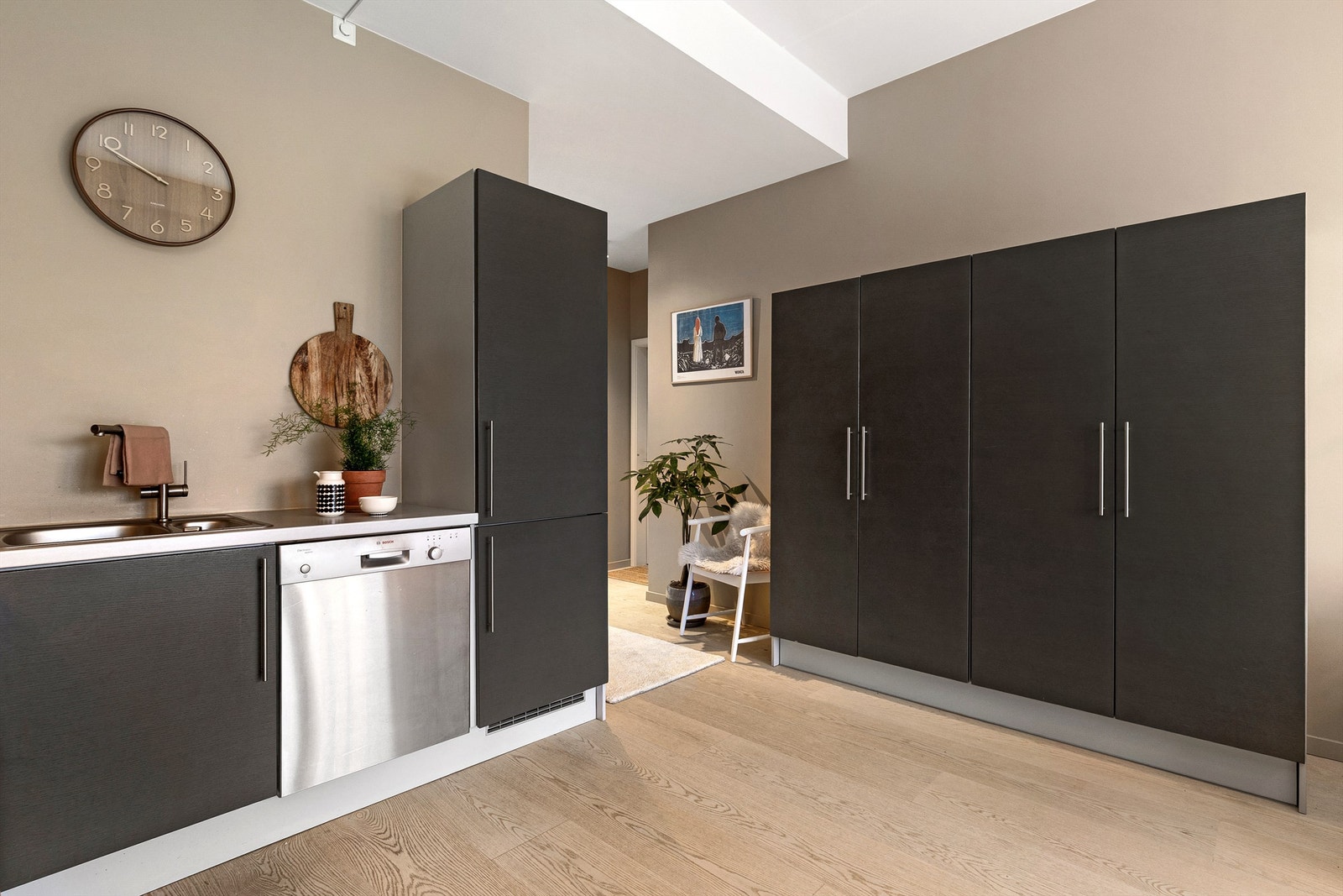 Skapene på motsatt side av kjøkkenet er garderobeskap med like fronter som kjøkkeninnredningen Galleribilde