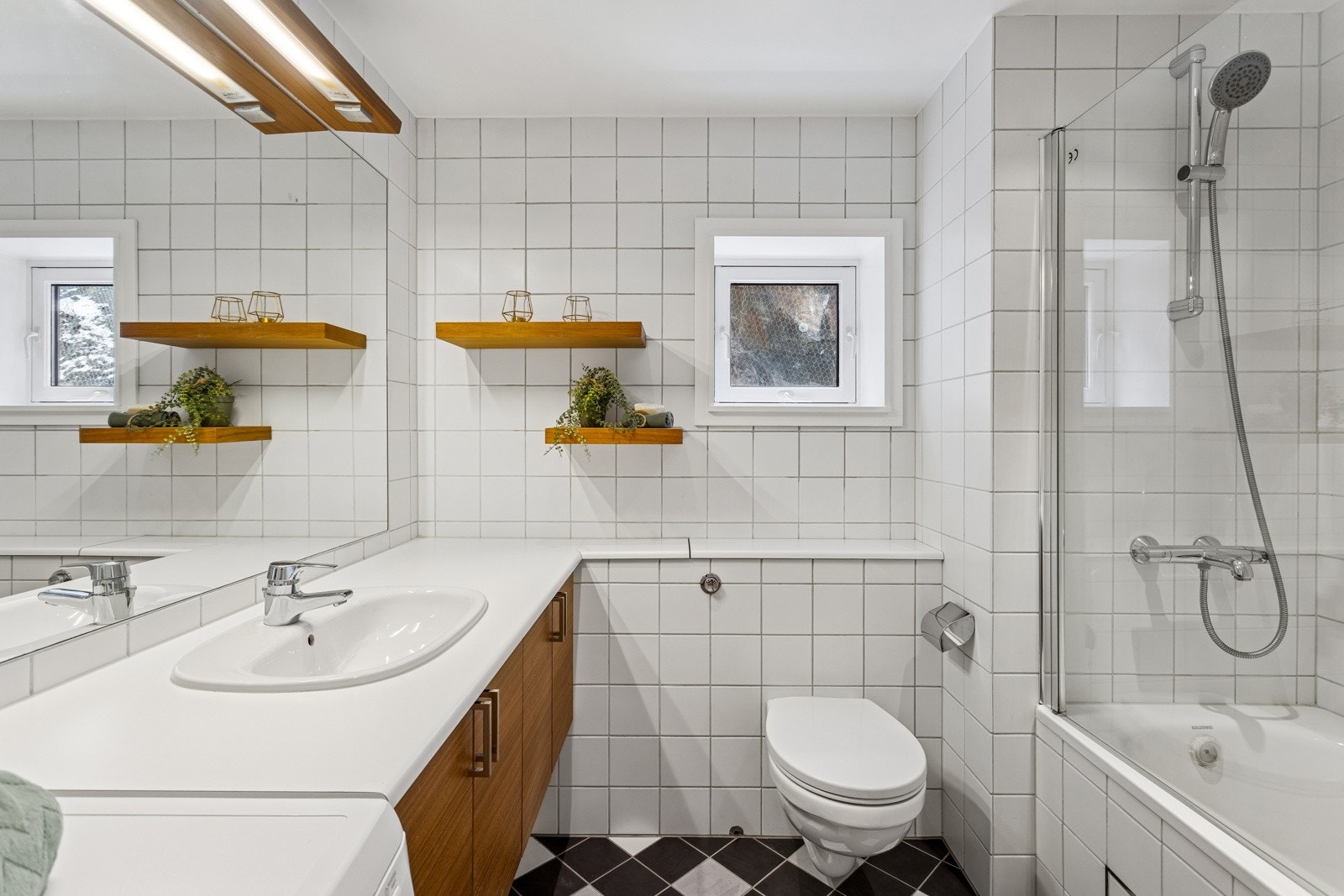 Pent bad med innfliset baderkar og veggmontert klosett. Galleribilde