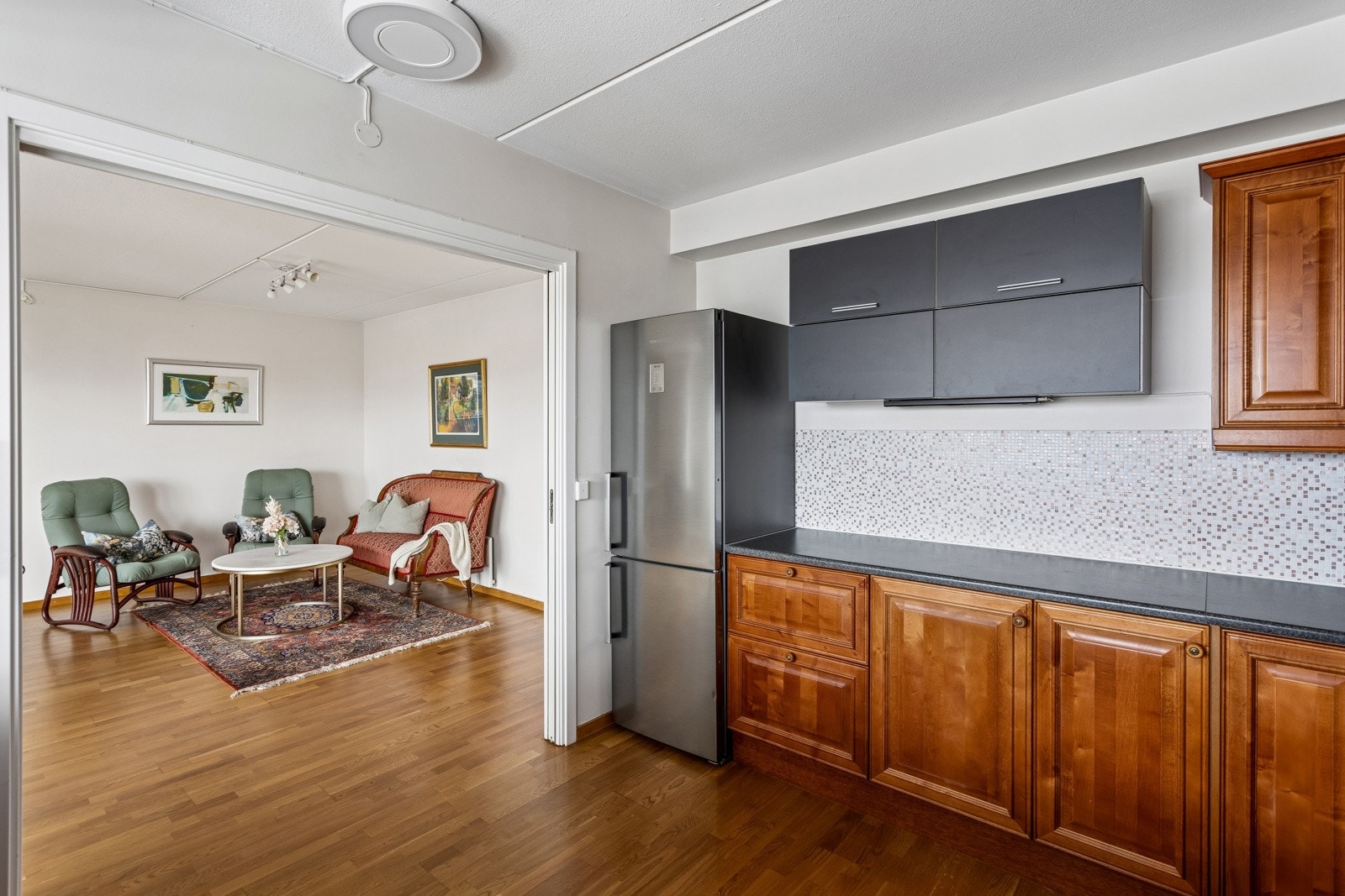 Åpen stue/kjøkkenløsning med gjennomgående parkettgulv. Galleribilde