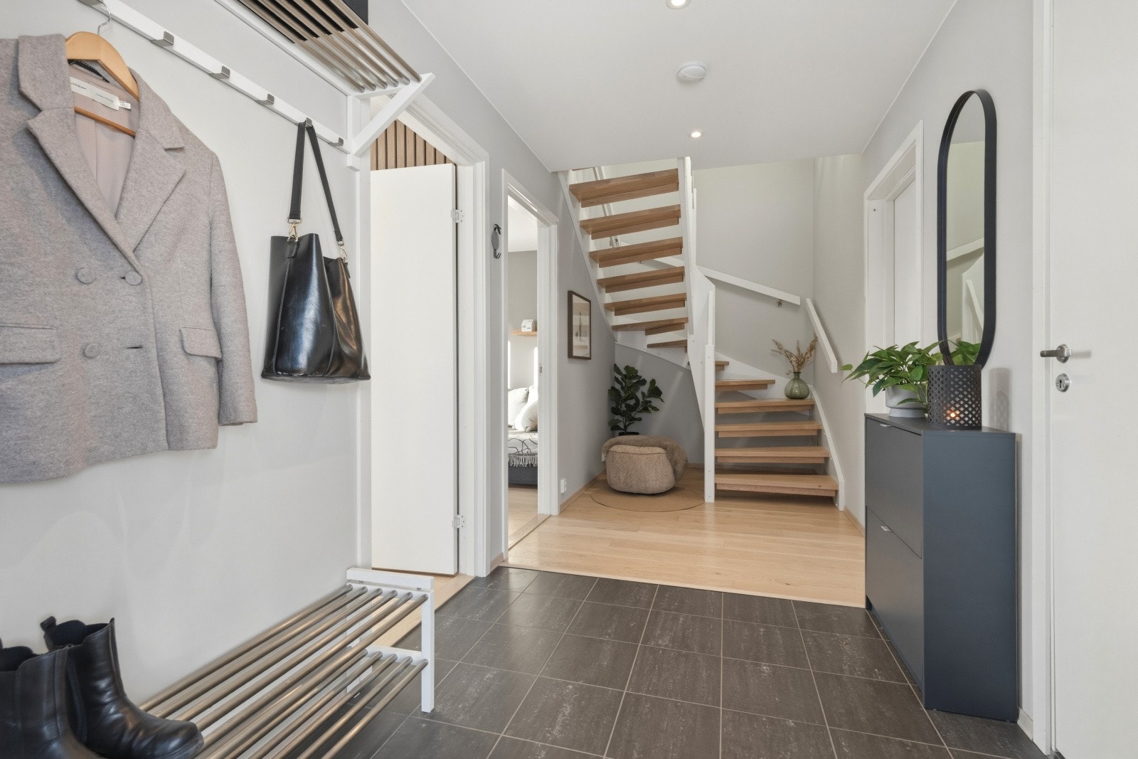 Man ønskes velkommen inn i en lys og romslig entré som er praktisk innredet med oppvarmet flislagt gulv. Her har man god plass til å henge fra seg yttertøy og sko. Galleribilde