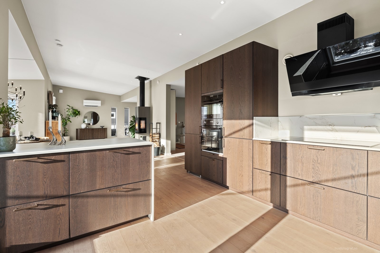 Inredningen er utført med slette fronter i eikefiner og keramiske benkeplater med underlimt vask av kompositt. Integrert induksjonstopp, stekeovn, micro, kjøleskap og oppvaskmaskin. Galleribilde