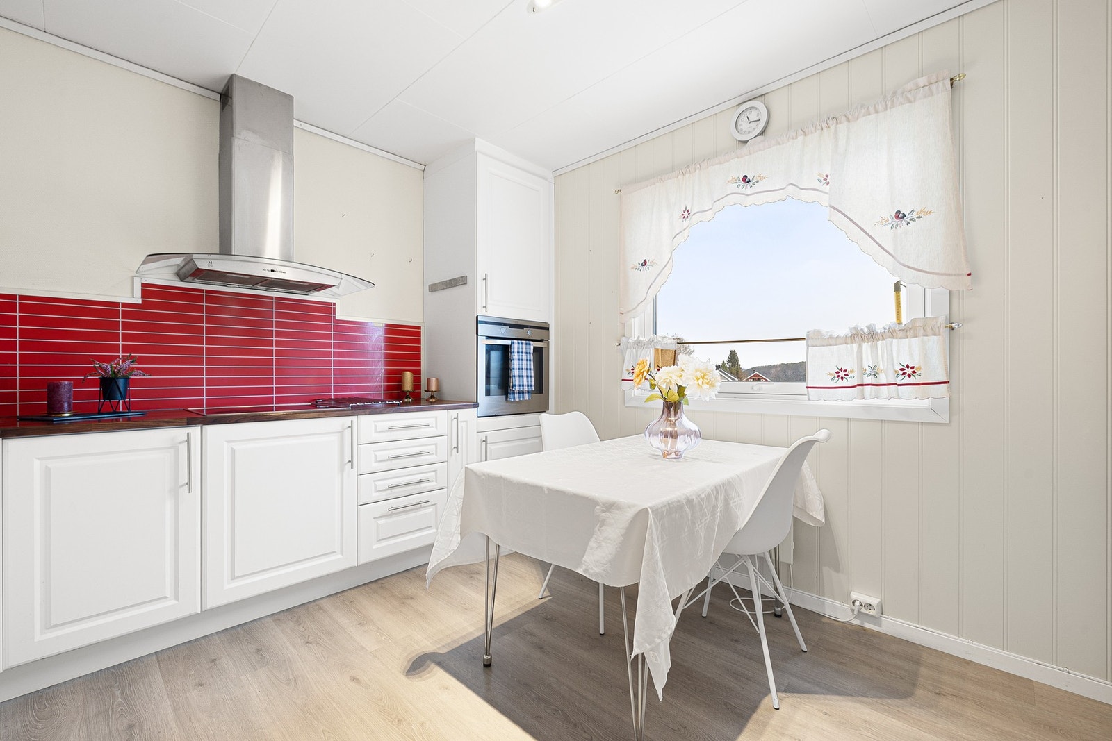 Veggmontert mekanisk avtrekksvifte over stekesonen, integrert stekeovn og platetopp. Galleribilde