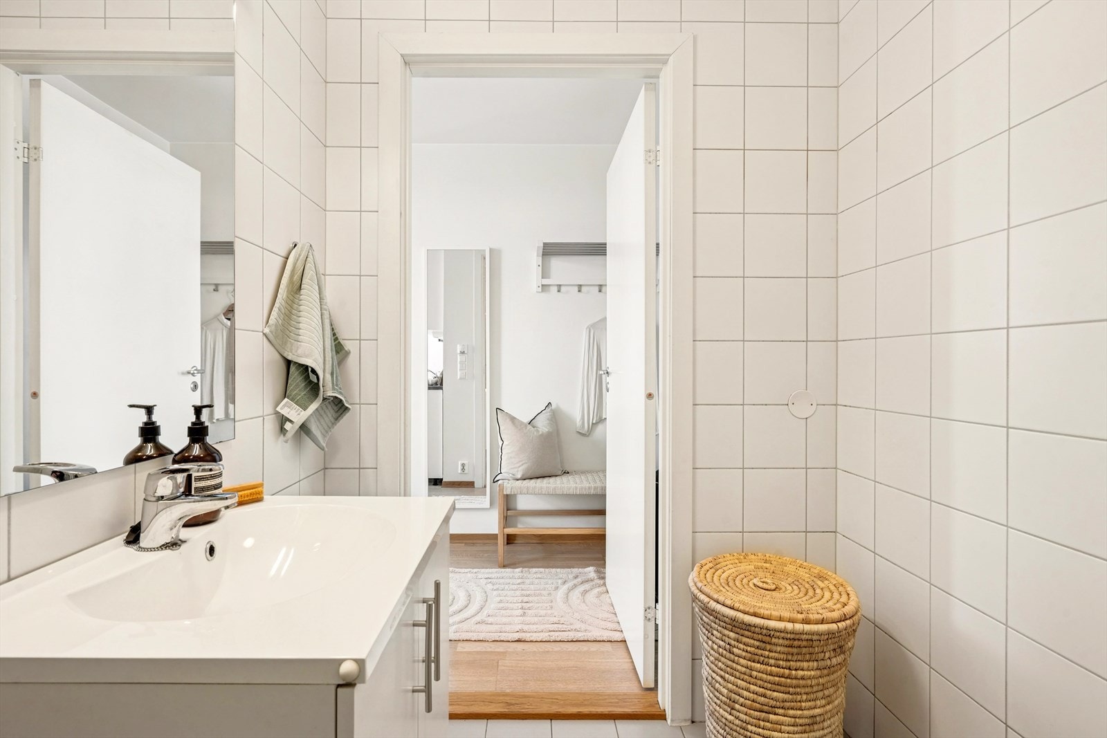 Det er utstyrt med servant, gulvstående klosett og dusj på gulv med dusjdører. Det er speil og belysning over servanten. Galleribilde