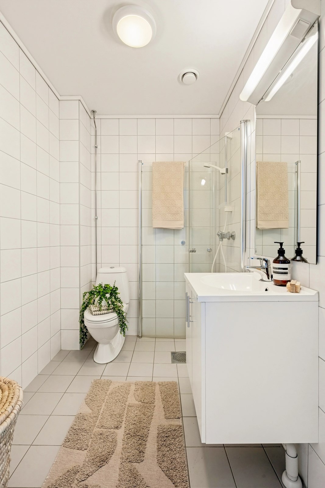 Flislagt baderom, pusset opp i regi av borettslaget i 2014. Badet har fliser på vegger og gulv, med sparklet og malt himling. Galleribilde