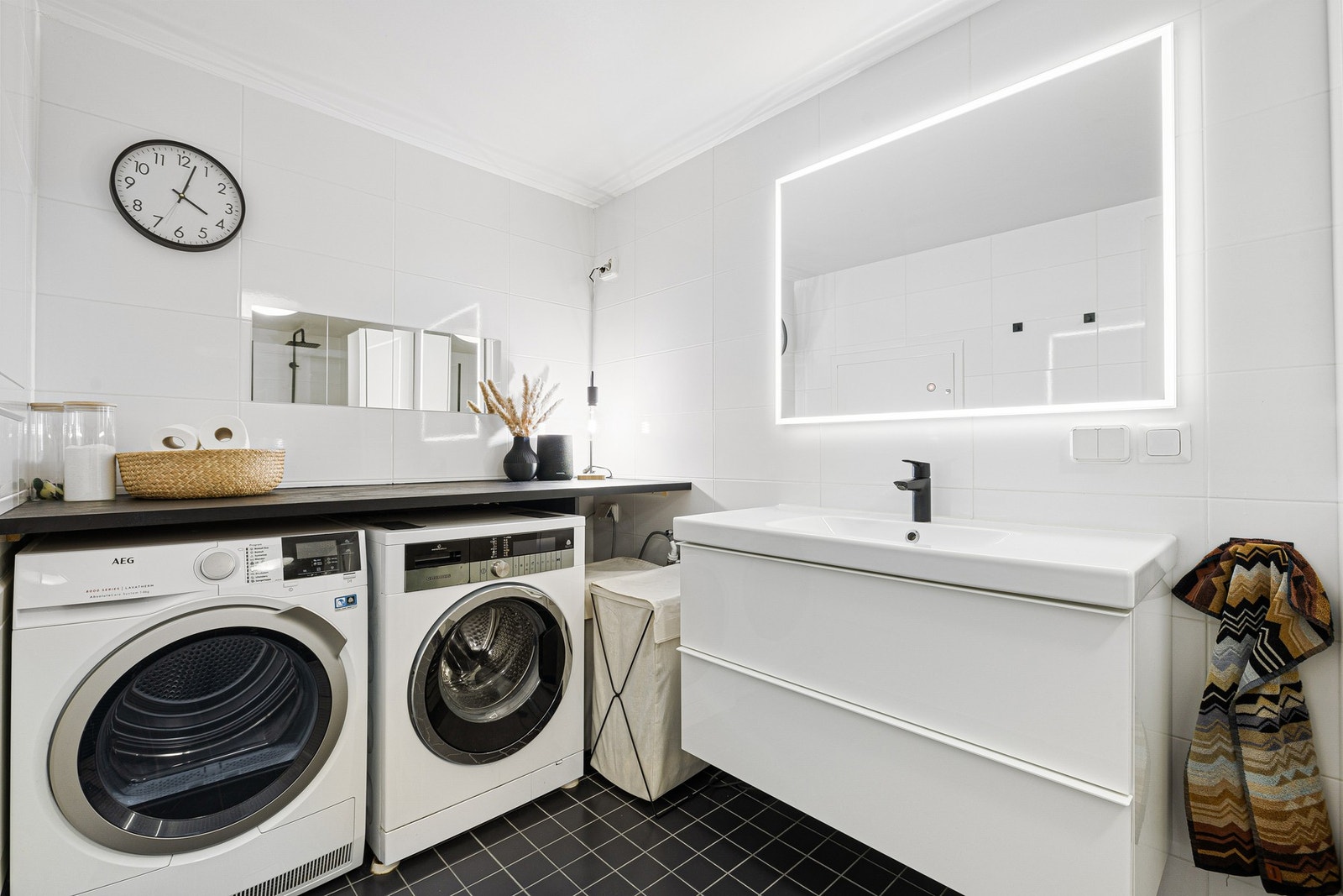 Badet er på 7,5 kvm, og det er lagt opp kran/avløp for vaskemaskin. I 2023 ble det montert en benkeplate over vaskesonen som strekker seg fra vegg til vegg. Galleribilde