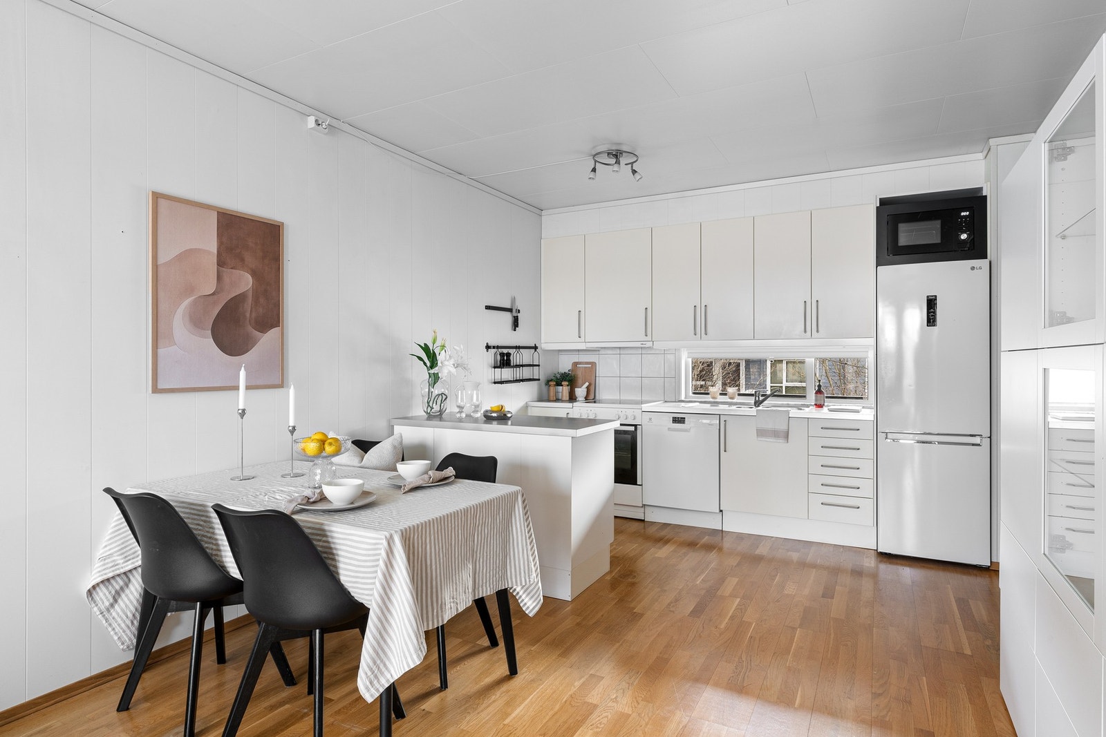 Den åpne løsningen gir plass til både sofa, tv-møblement og spisebord ved kjøkkensonen Galleribilde