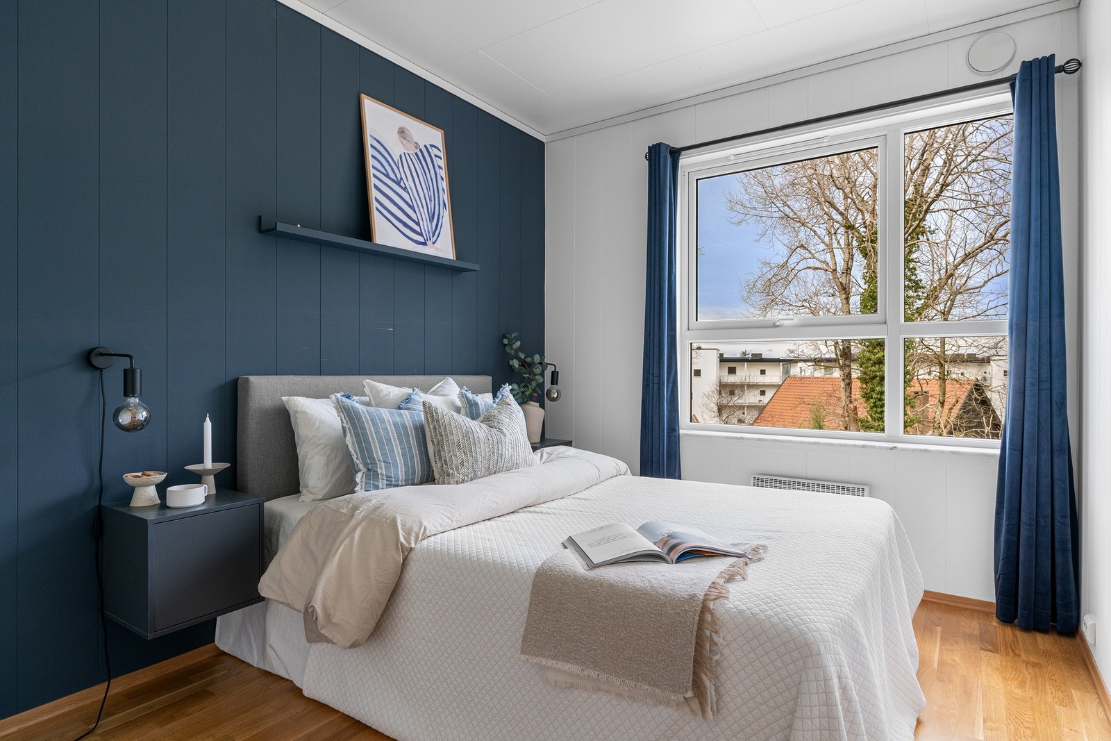 Leiligheten har et soverom med god plass til dobbeltseng, nattbord og garderobeskap. Galleribilde