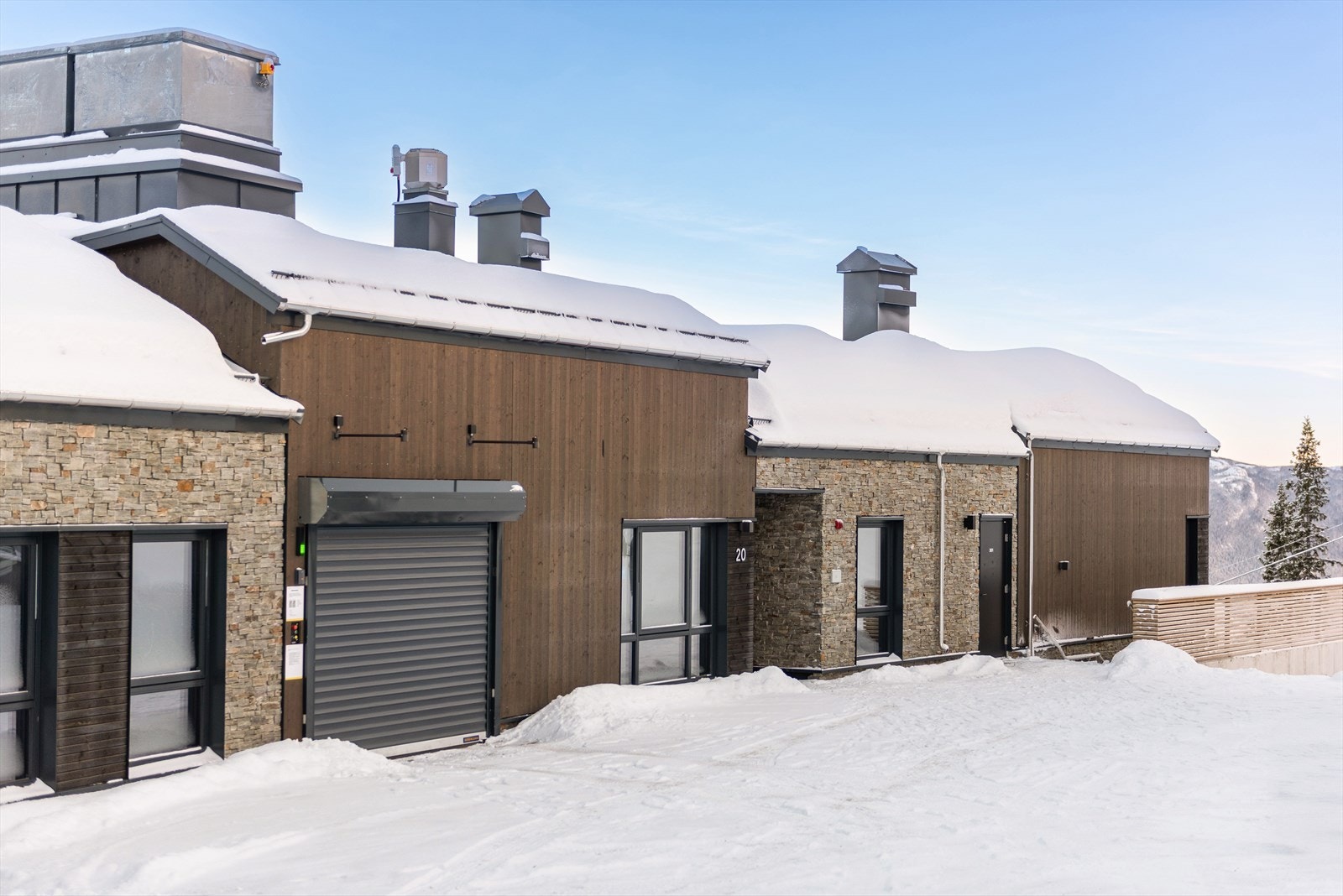 Innkjøring for heis til garasje på oversiden av bygget. Felles inngang til leilighetsbygget. Galleribilde