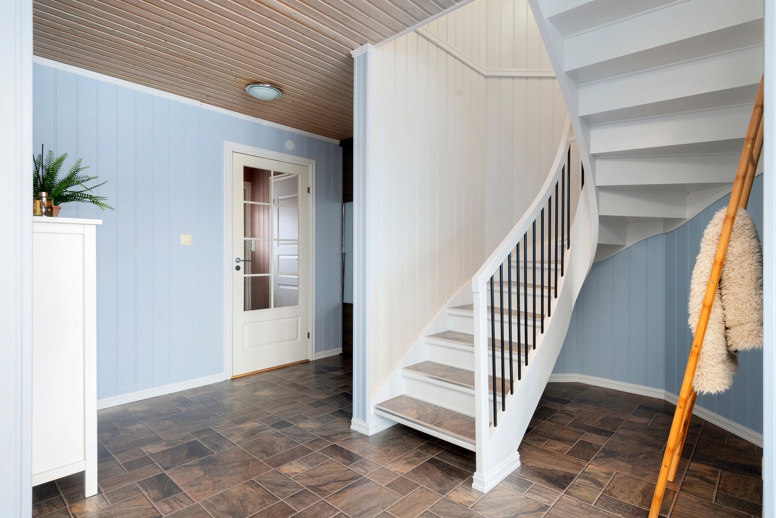 Stue - Lys svingtrapp i tre med laminatbelagte trinn og sort gelender. Det er også gode oppbevaringsmuligheter under trappen. Galleribilde