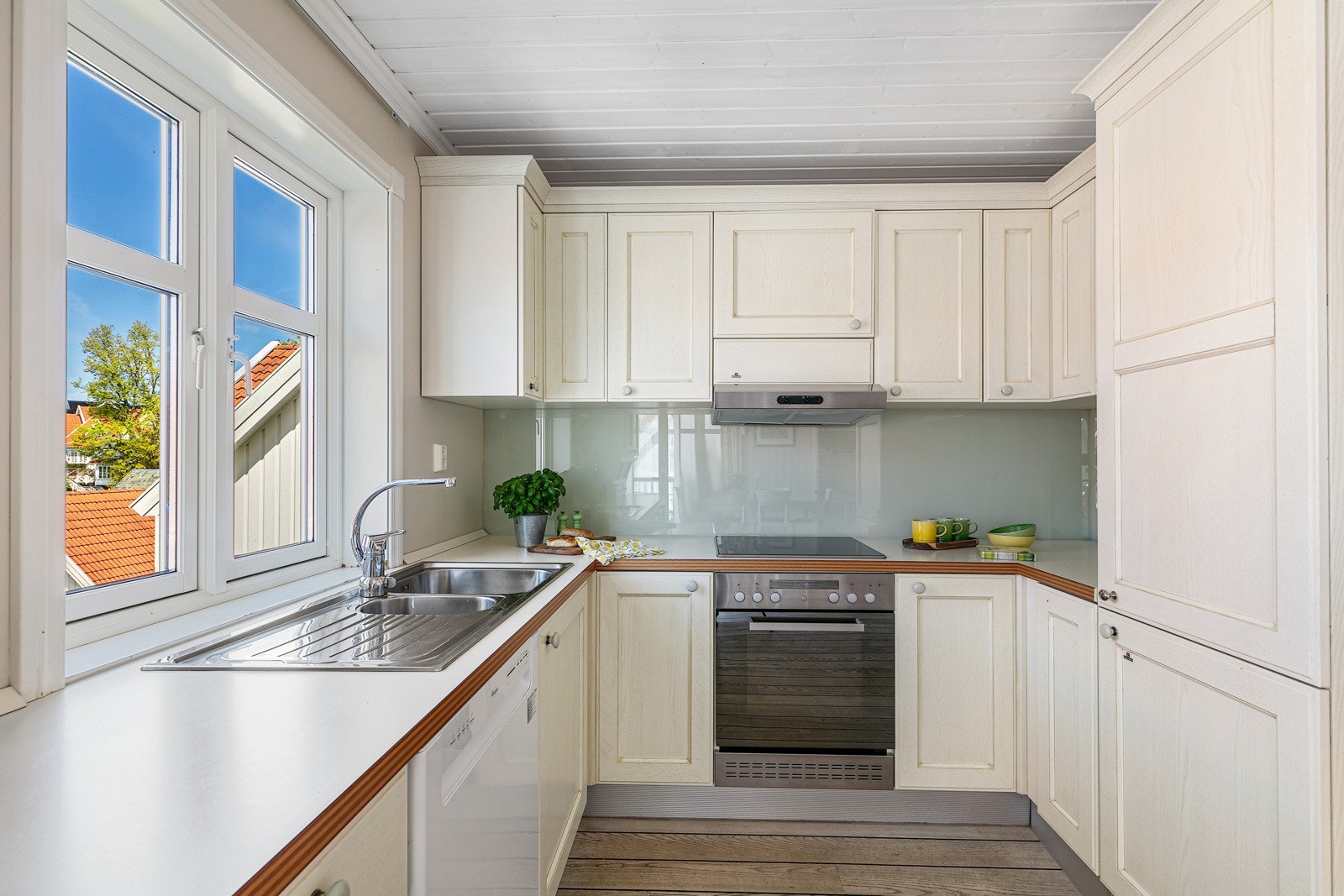 Kjøkkeninnredning med profilerte fronter, integrerte hvitevarer og oppvaskmaskin. Galleribilde