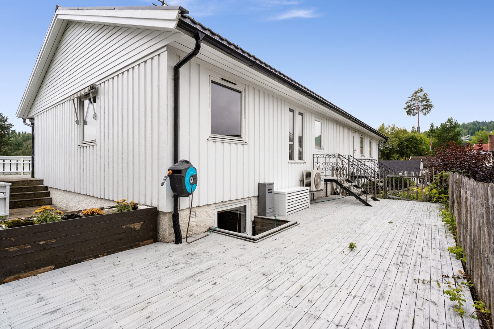 Stor terrasse på baksiden av huset med utgang fra vaskerommet Galleribilde