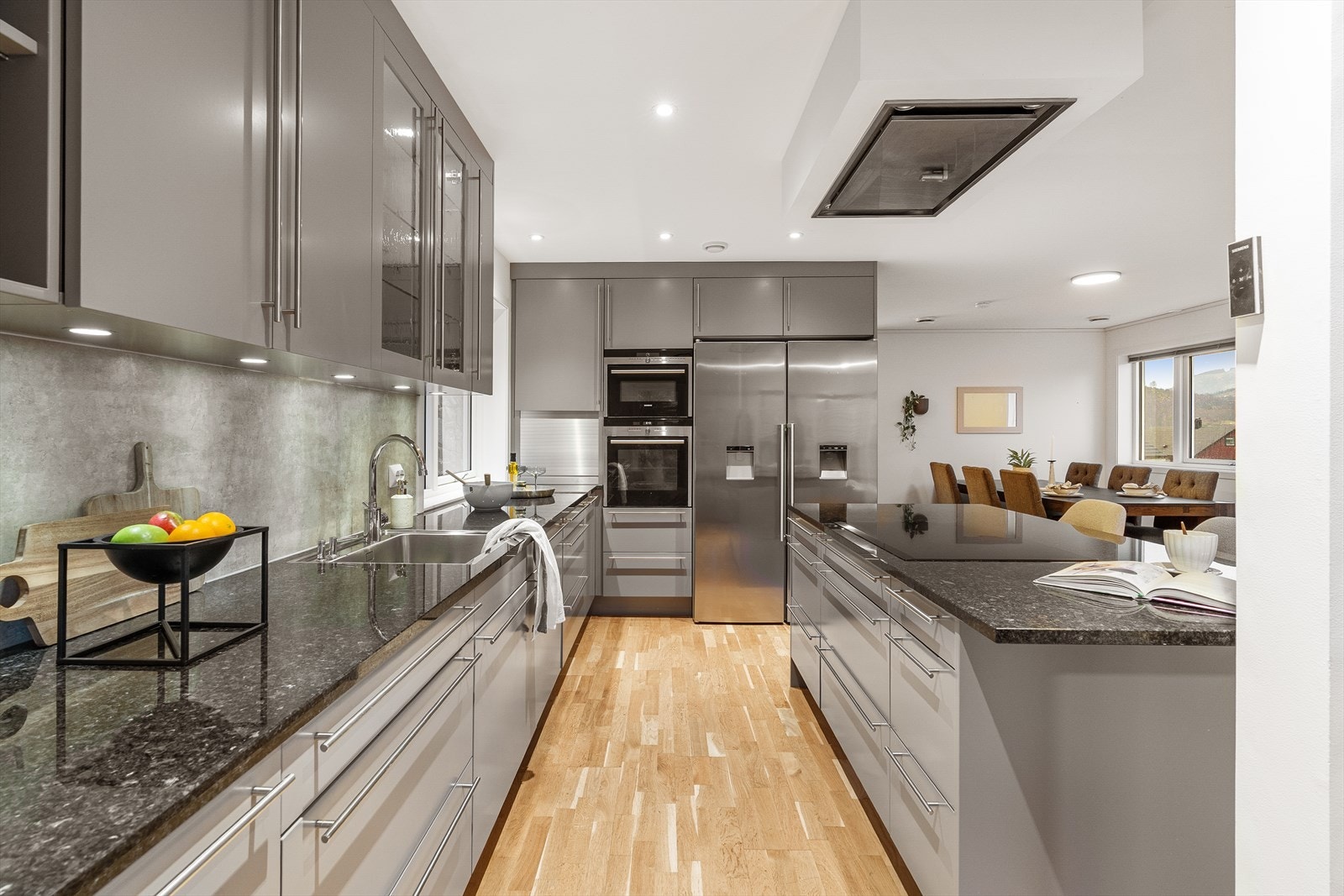 Godt med skuffeplass, benkeplate i granitt og grå fronter som skaper et stilrent uttrykk. Galleribilde