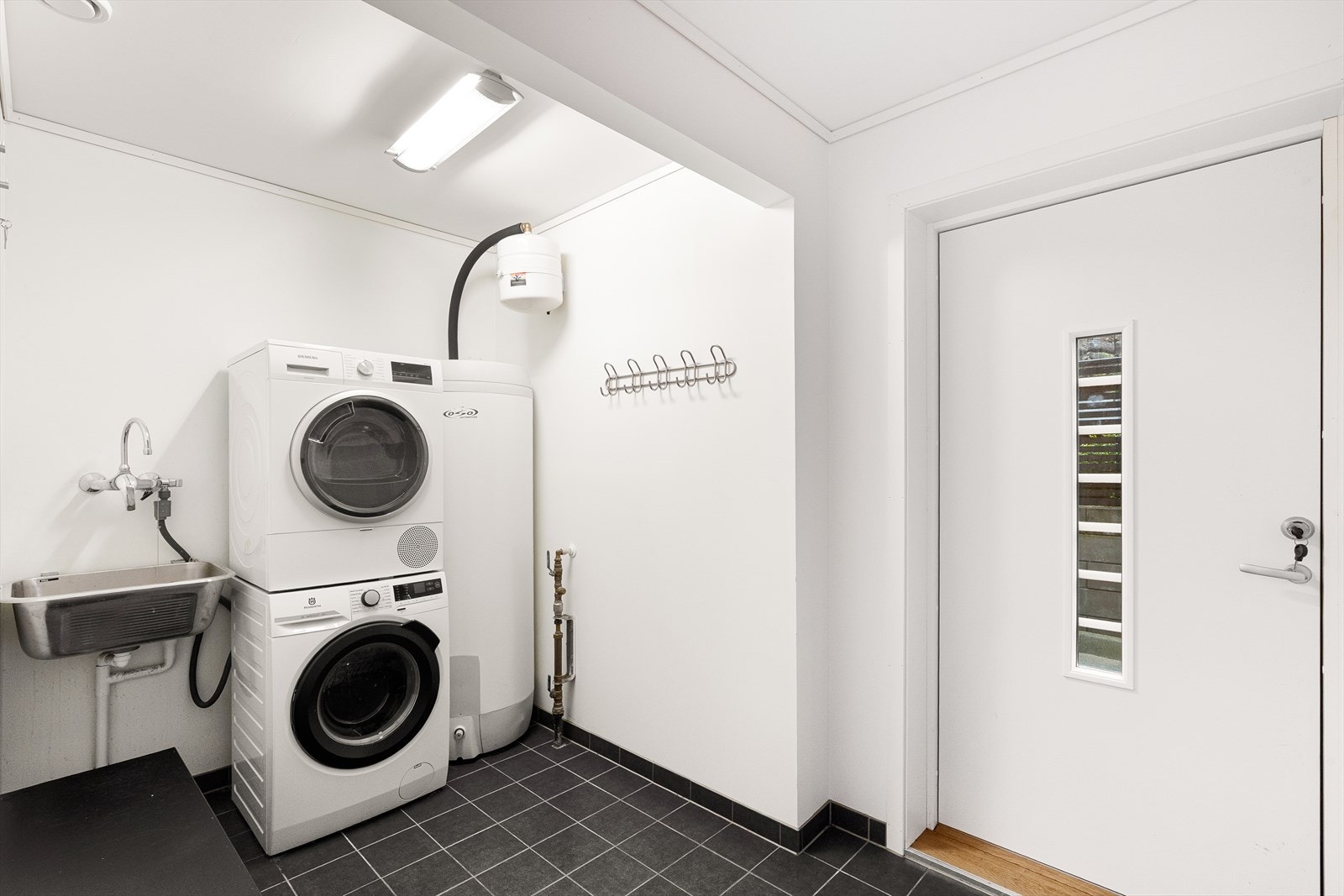 Vaskerom med bi-inngang. Fliser på gulv og plass til innredning. Galleribilde