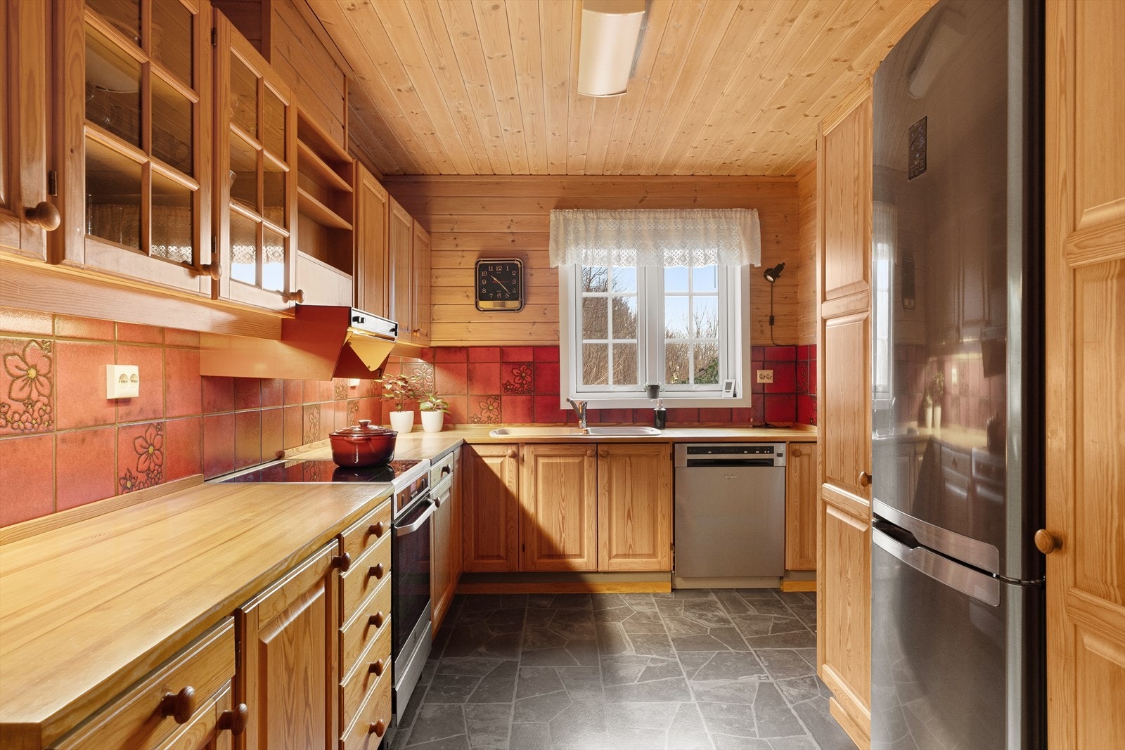 Kjøkkenet har gode oppbevaringsmuligheter i skuffer og skap. Frittstående komfyr, kjøleskap og oppvaskmaskin. Galleribilde