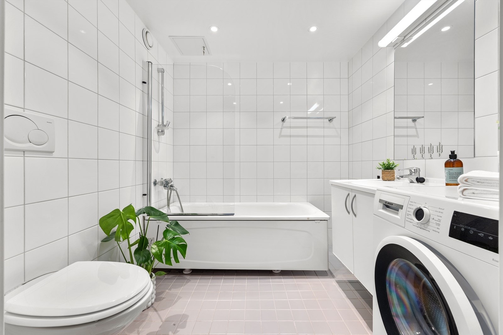 Flislagt baderom med opplegg for vaskemaskin, elektriske varmekabler i gulvet og innfelt belysning i himlingen. Galleribilde