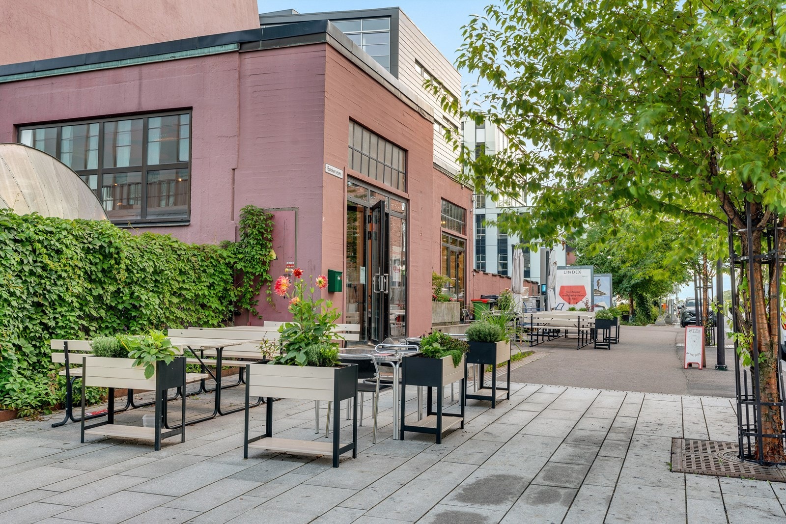 Utendørs sitteplasser ved lokal kafé skaper et hyggelig miljø. Galleribilde