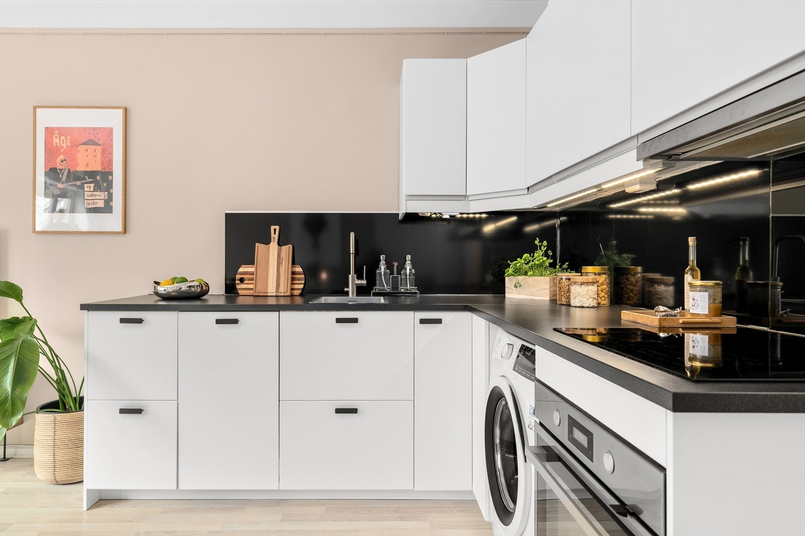 Laminat benkeplate med nedfelt stålkum og ventilator med kullfilter over kokesonen. Galleribilde