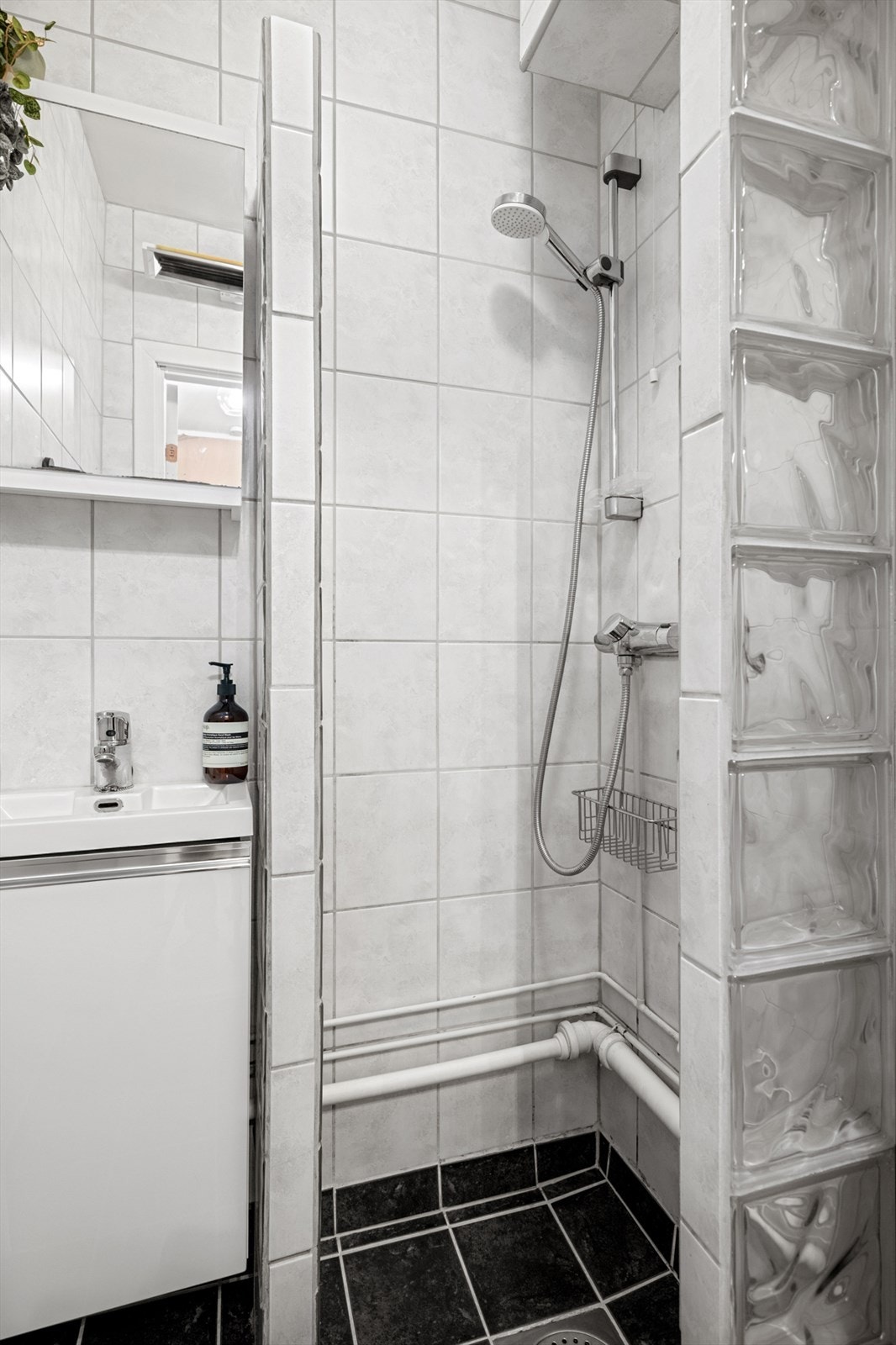 Dusjhjørnet er utformet med glassbyggerstein, og badet har elektrisk avtrekksvifte. Galleribilde