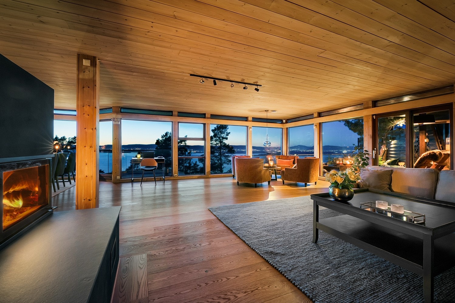 Stuen byr på lun kveldsstemning med store vindusflater som rammer inn utsikten. Galleribilde