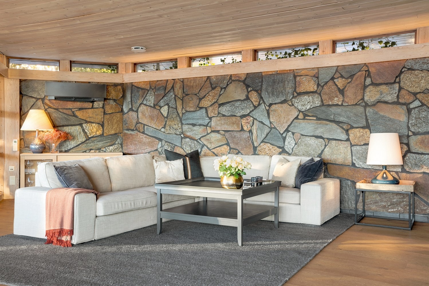 Stuen er lun og innbydende med nydelig natursteinsvegg som gir et særegent preg til rommet. Galleribilde