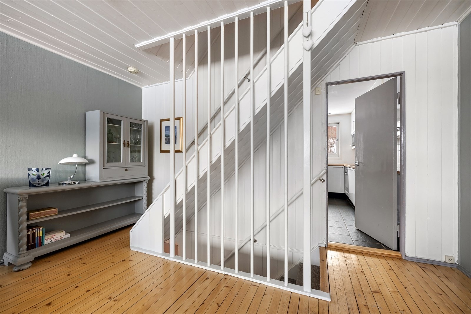 En malt teppebelagt tretrapp binder boligens etasjer sammen på en elegant måte. Galleribilde