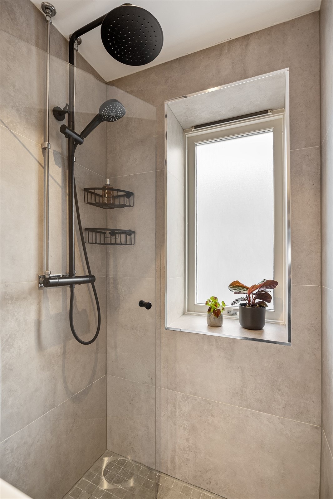 Her er det vegghengt toalett, dusjhjørne med glassdør og opplegg for vaskemaskin. Galleribilde