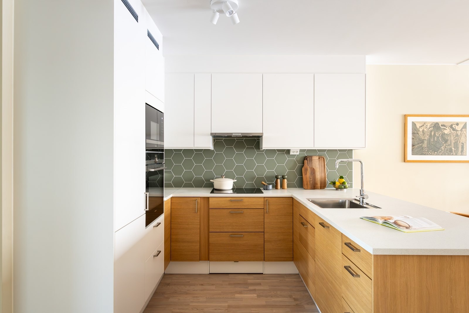 Kjøkkeninnredningen består av glatte, hvite og eik fronter og benkeplate av laminat med nedfelt vaskekum. Galleribilde