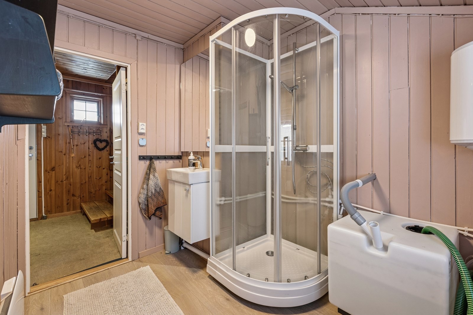 Badet er oppgradert og innredet med dusjkabinett og baderomsmøbel med vask. Galleribilde