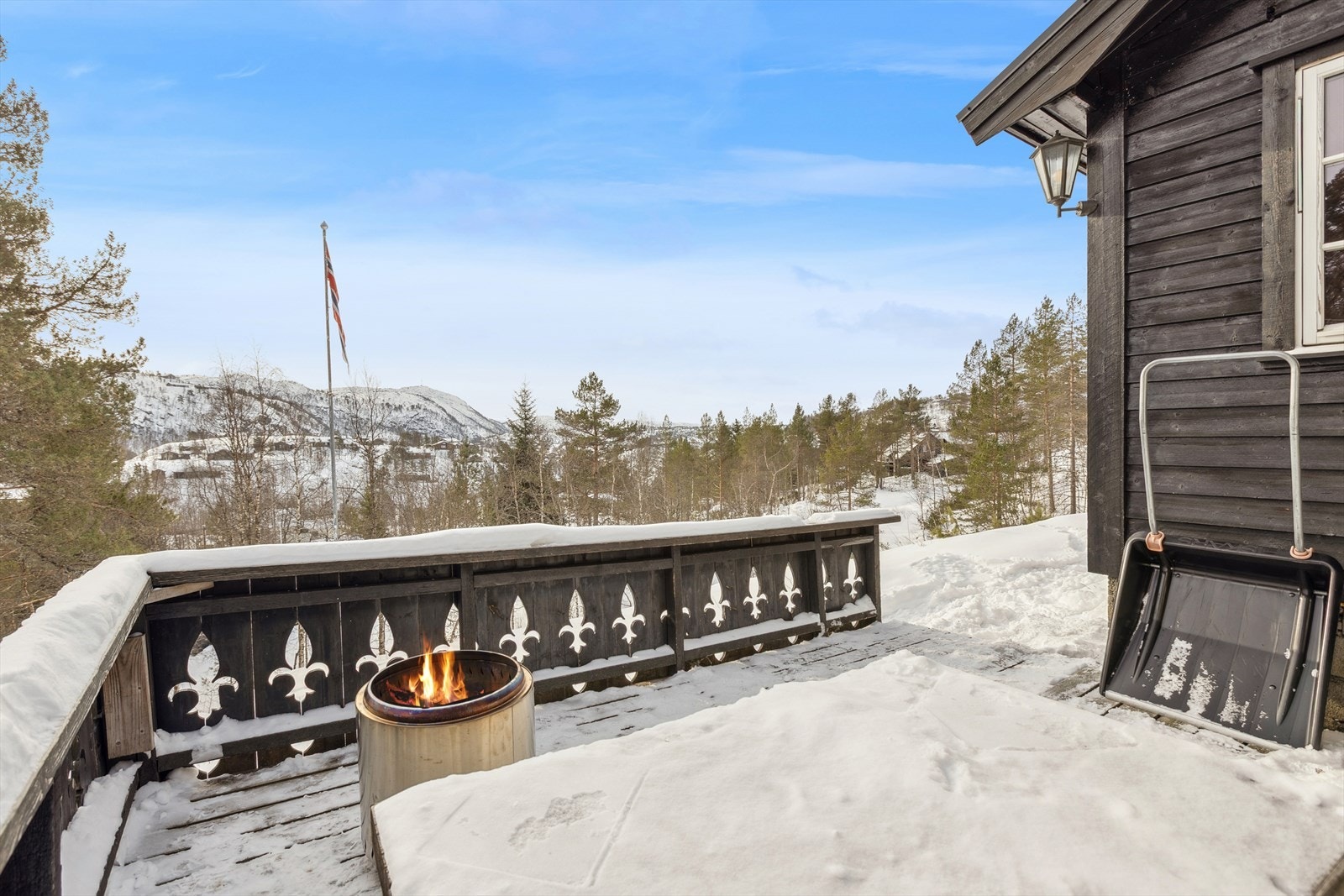 Terrassen er bygget i tre og har et tradisjonelt rekkverk. Galleribilde