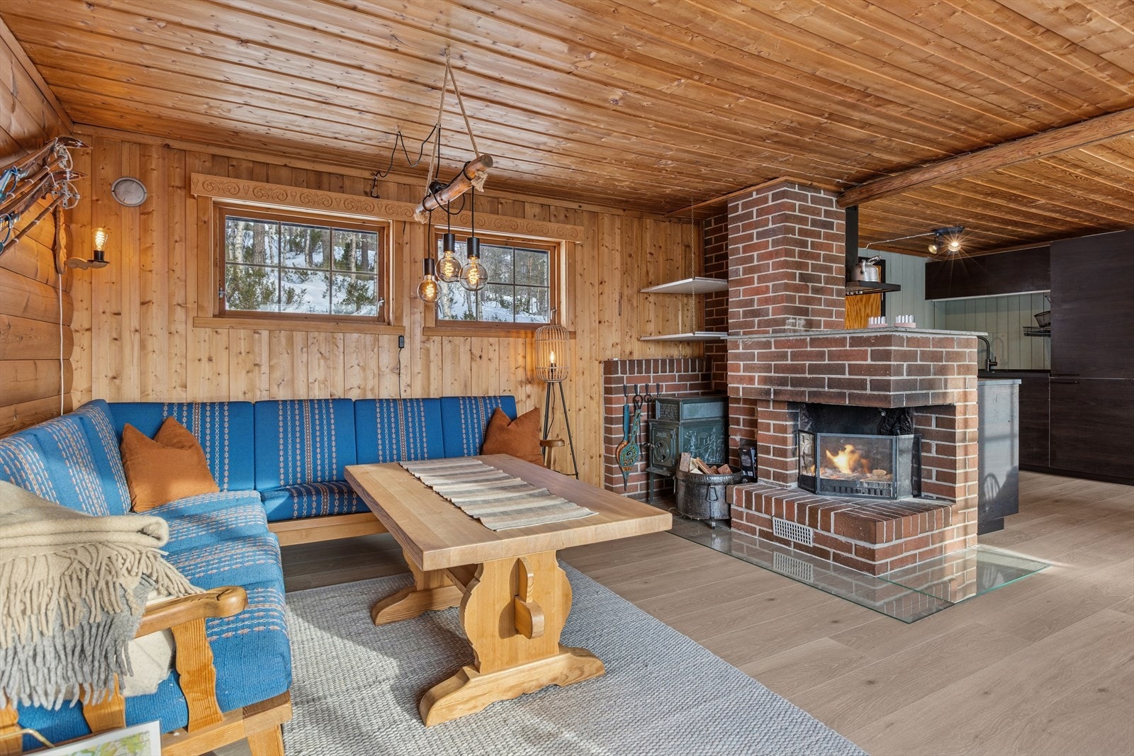 Den sentralt plasserte teglpipen har både åpen peis og vedovn for varme og hygge. Galleribilde