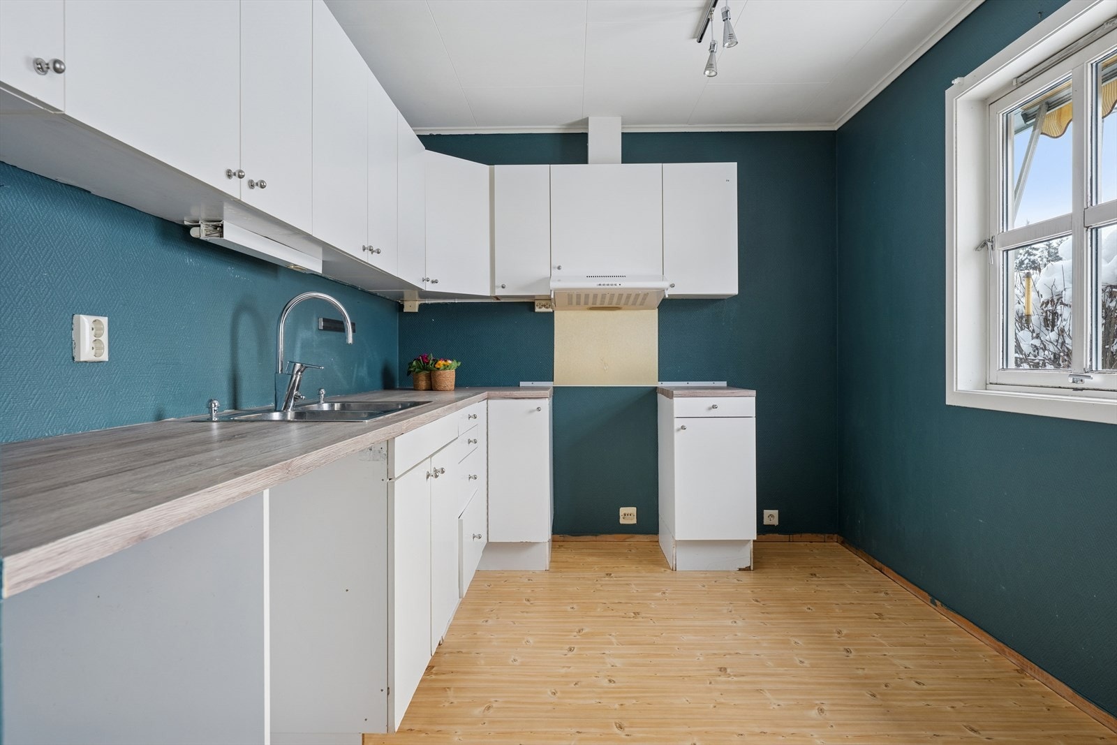 Kjøkkeninnredning med glatte fronter og plass til frittstående hvitevarer. Galleribilde