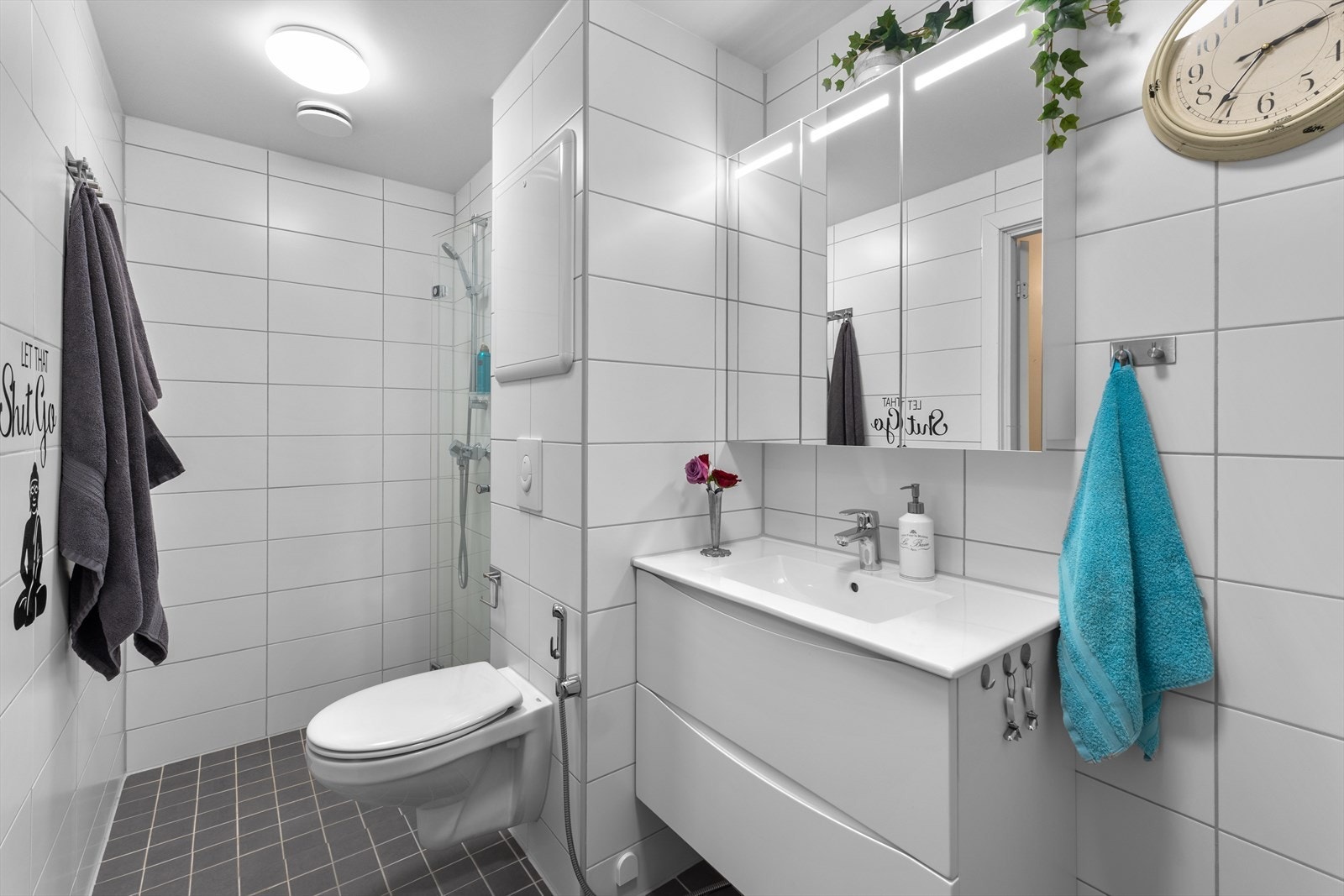 Flislagt bad oppusset i regi av borettslaget i 2022. Badet har dusjhjørne, vegghengt toalett, hånddusj til toalettet, servant med underskuffer og speilskap med belysning. Galleribilde