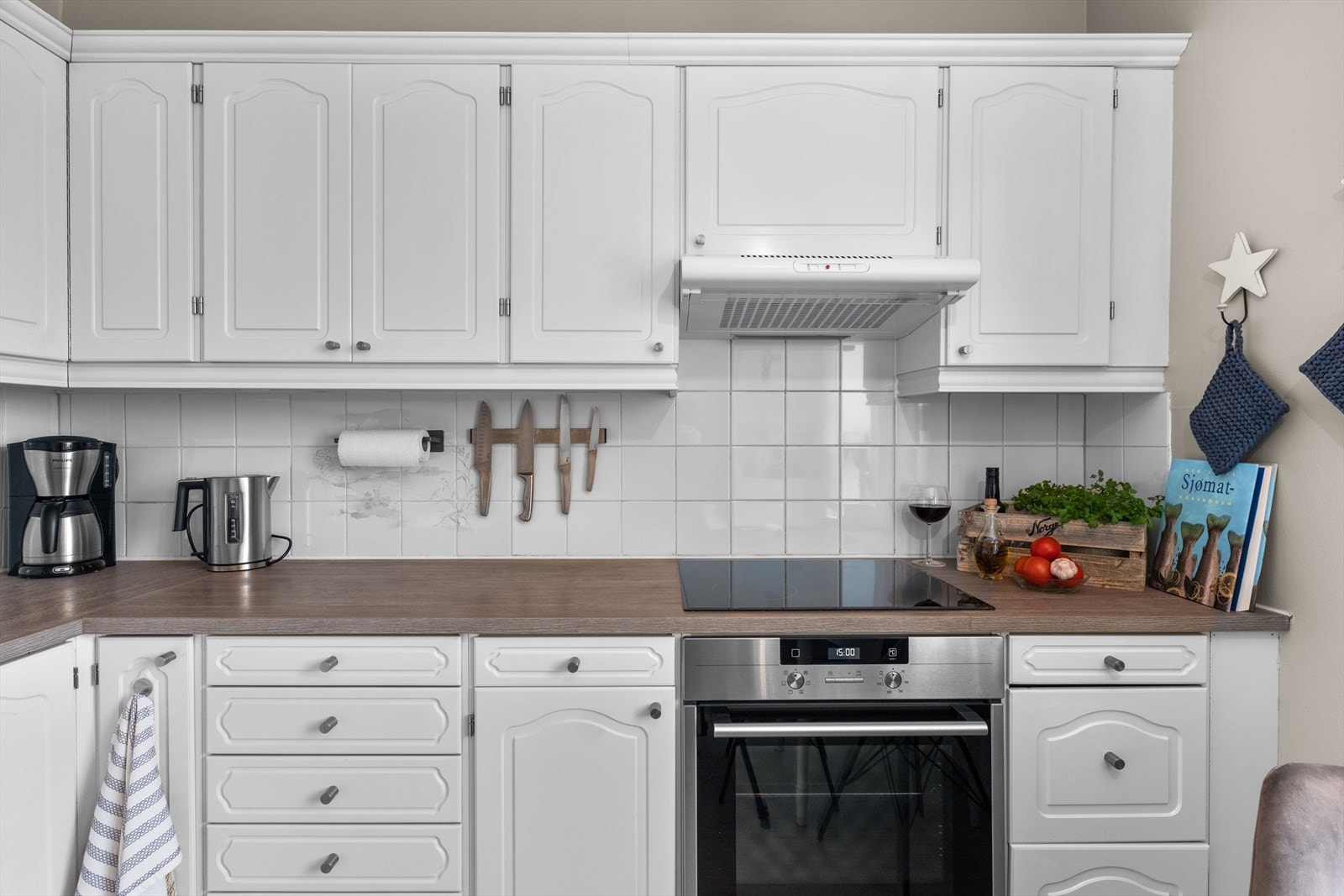 Innredningen består av profilerte fronter og benkeplate i laminat. Mellom over- og underskap er det fliser. Galleribilde