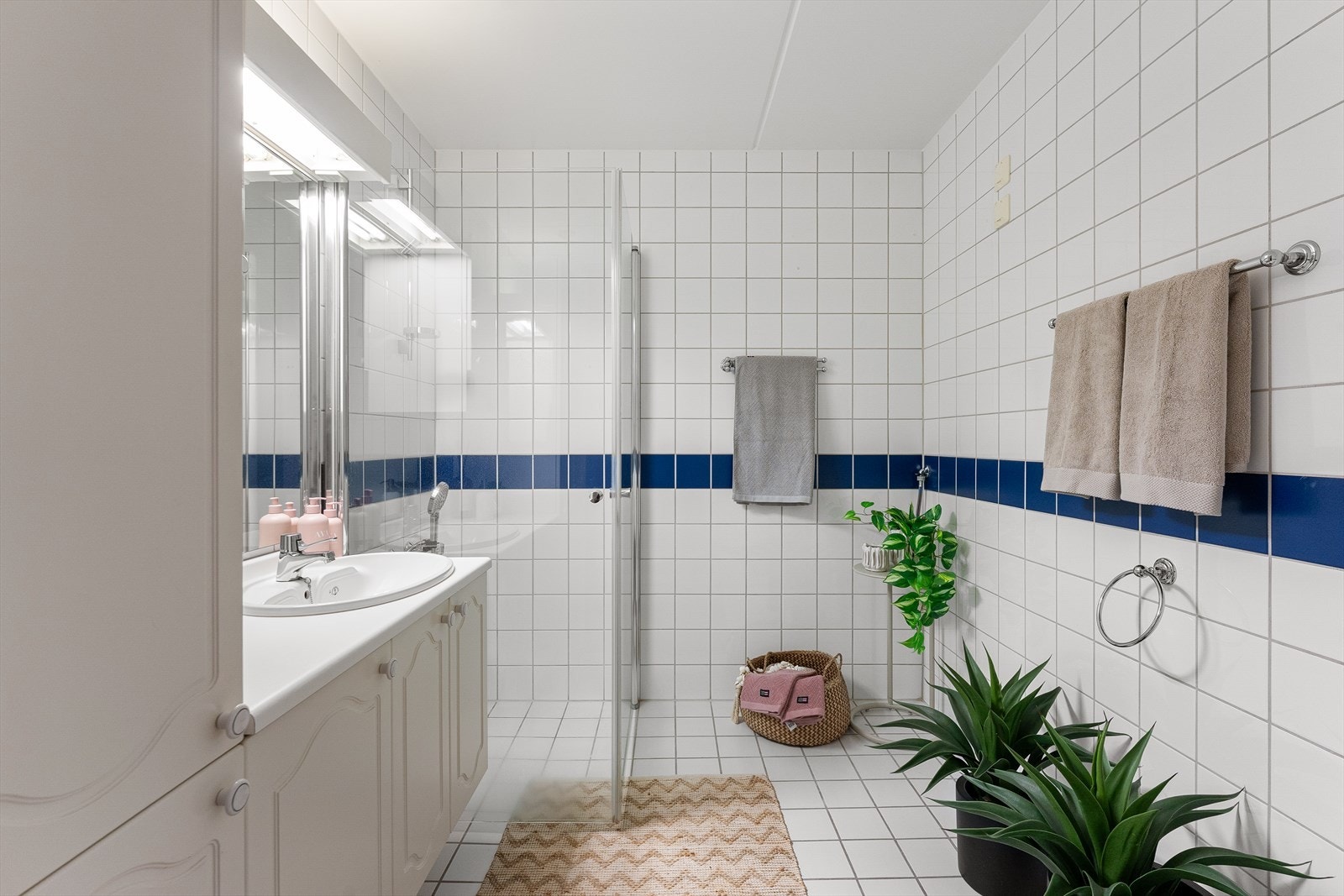 Hovedbad innredet med dusj, servantskap og toalett Galleribilde