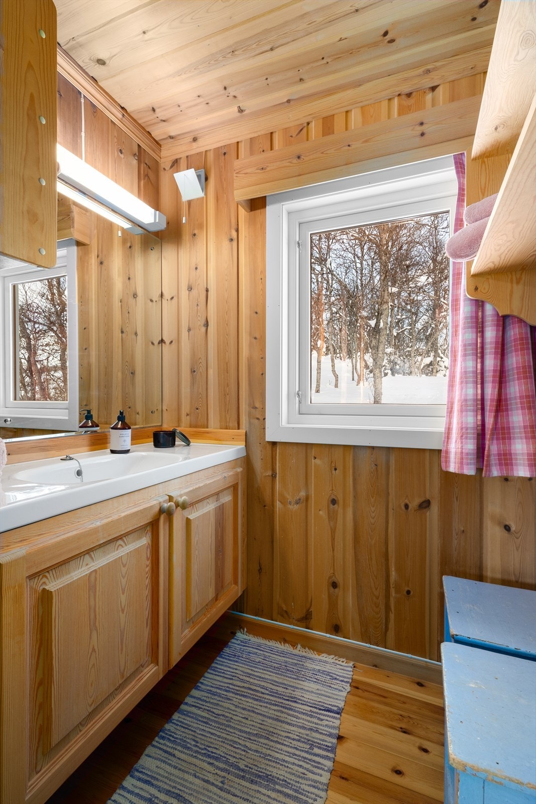 Hytta har et enkelt stellerom med servantskap, speil og overlys, samt veggmonterte hyller for oppbevaring. Galleribilde