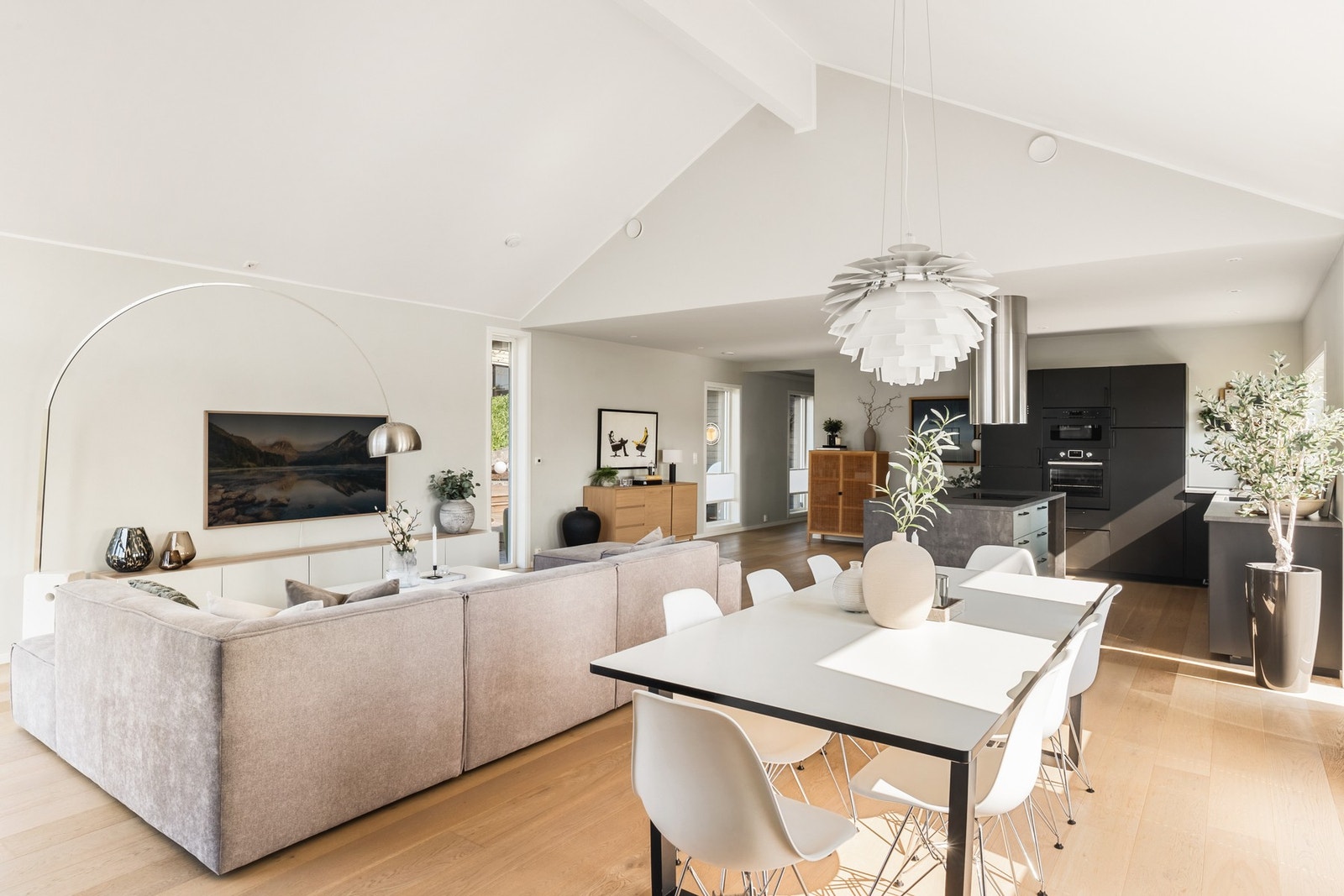 Den sosiale og åpne løsningen mellom stue og kjøkken er perfekt når du har gjester på besøk. Galleribilde