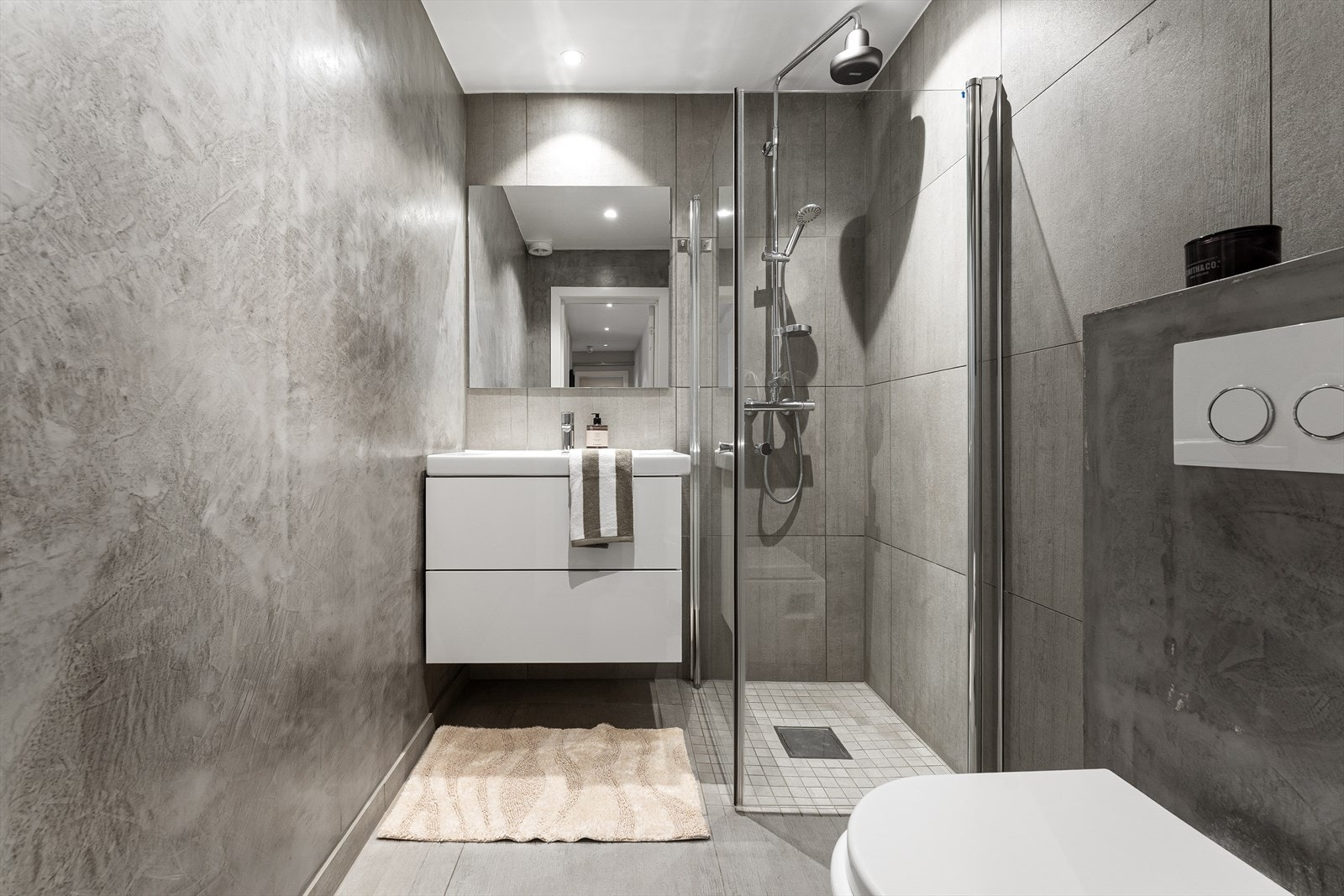 Lyst og stilrent bad fra 2016 med flislagte overflater og varmekabler i gulvet. Galleribilde