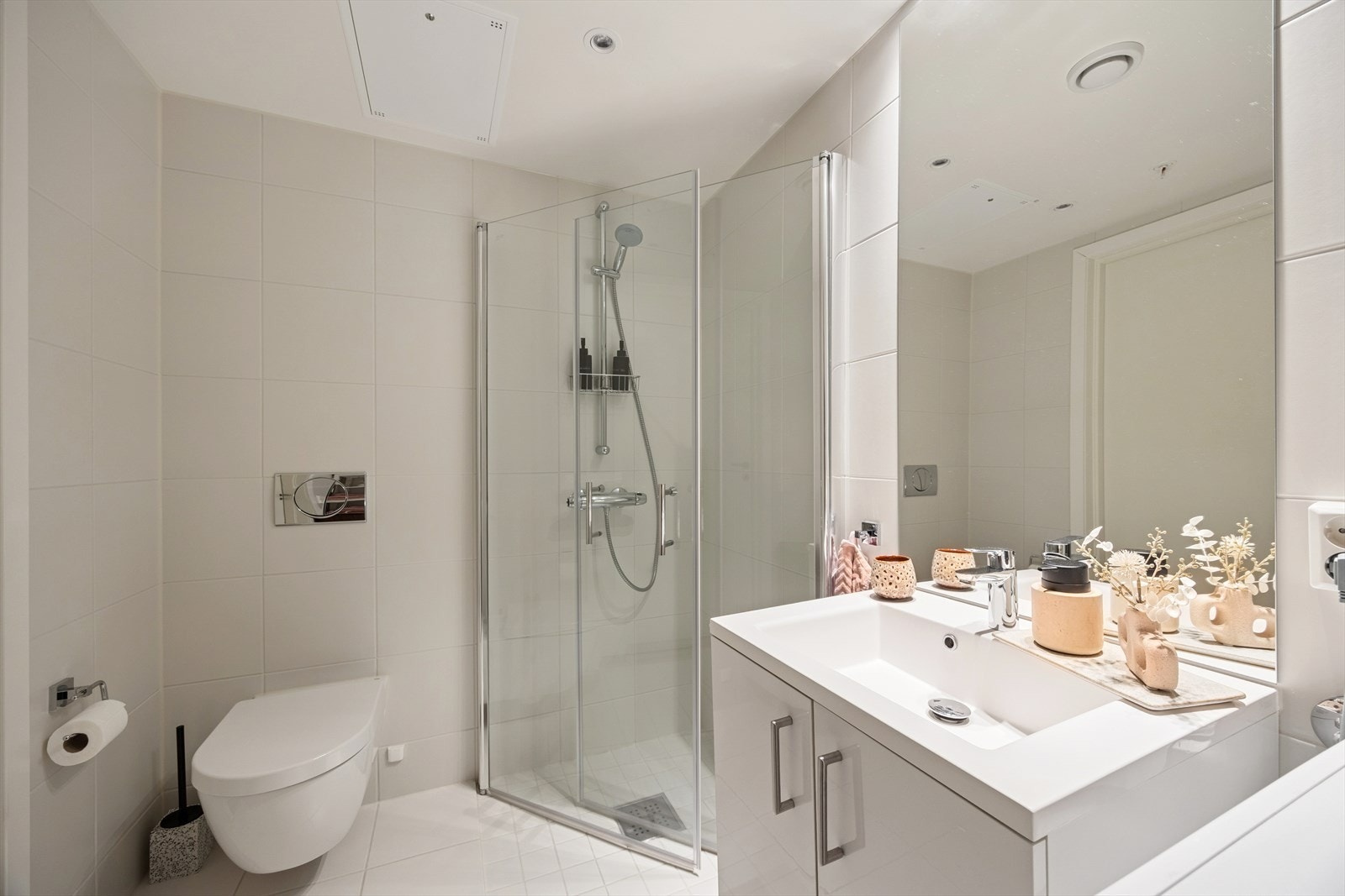 Innredningen består av vegghengt wc, servant m/underskap, speil og dusjsone med innfellbare glassdører. Galleribilde