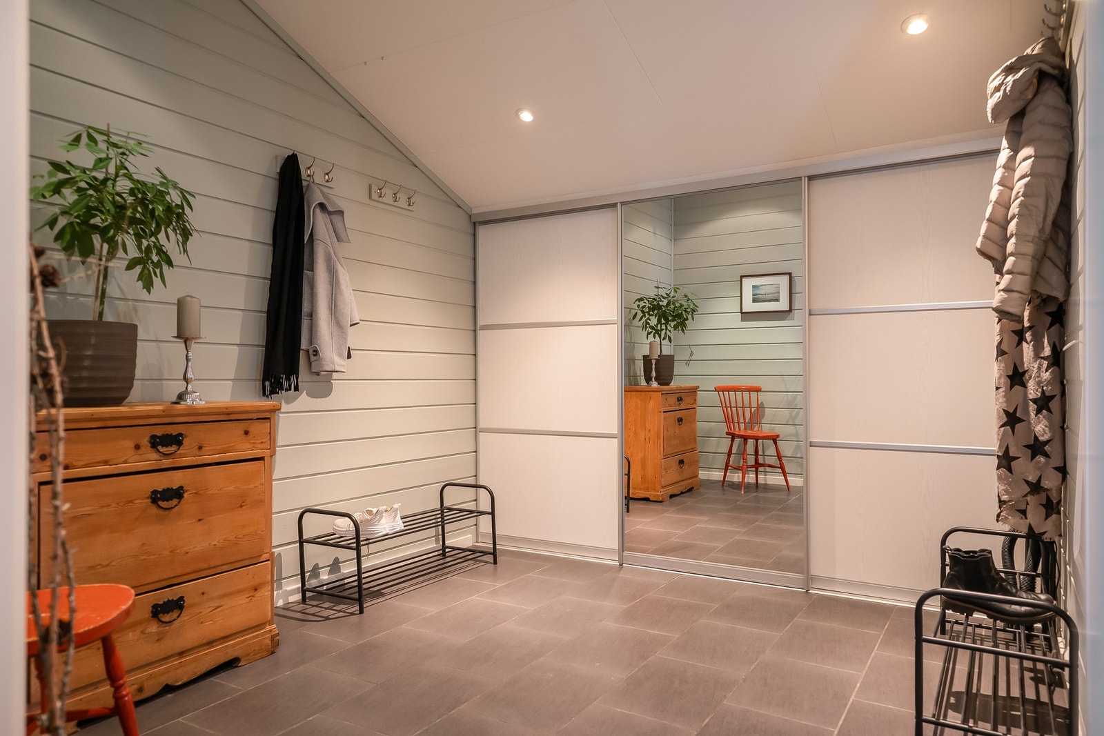 Stor og flott entré med varmekabler under flislagt gulv, downlights i tak og godt med oppbevaringsplass i skyvedørsgarderobe Galleribilde